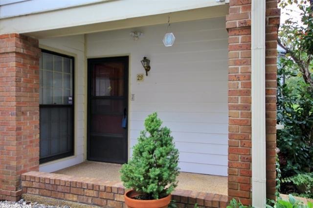 This is a ground level end unit.  Tile floor in entry and bathroom. Carpet in living/dining room & bedrooms. Large Living Room has fireplace, ceiling fan, and access to patio. Kitchen with wood cabinets, stainless double sink, microwave, oven, smooth surface range, dishwasher & trash compactor. Spacious bathroom w/linen closet, vanity w/double sinks, separate walk-in shower, and whirlpool tub. Covered porch in back with outside storage space.