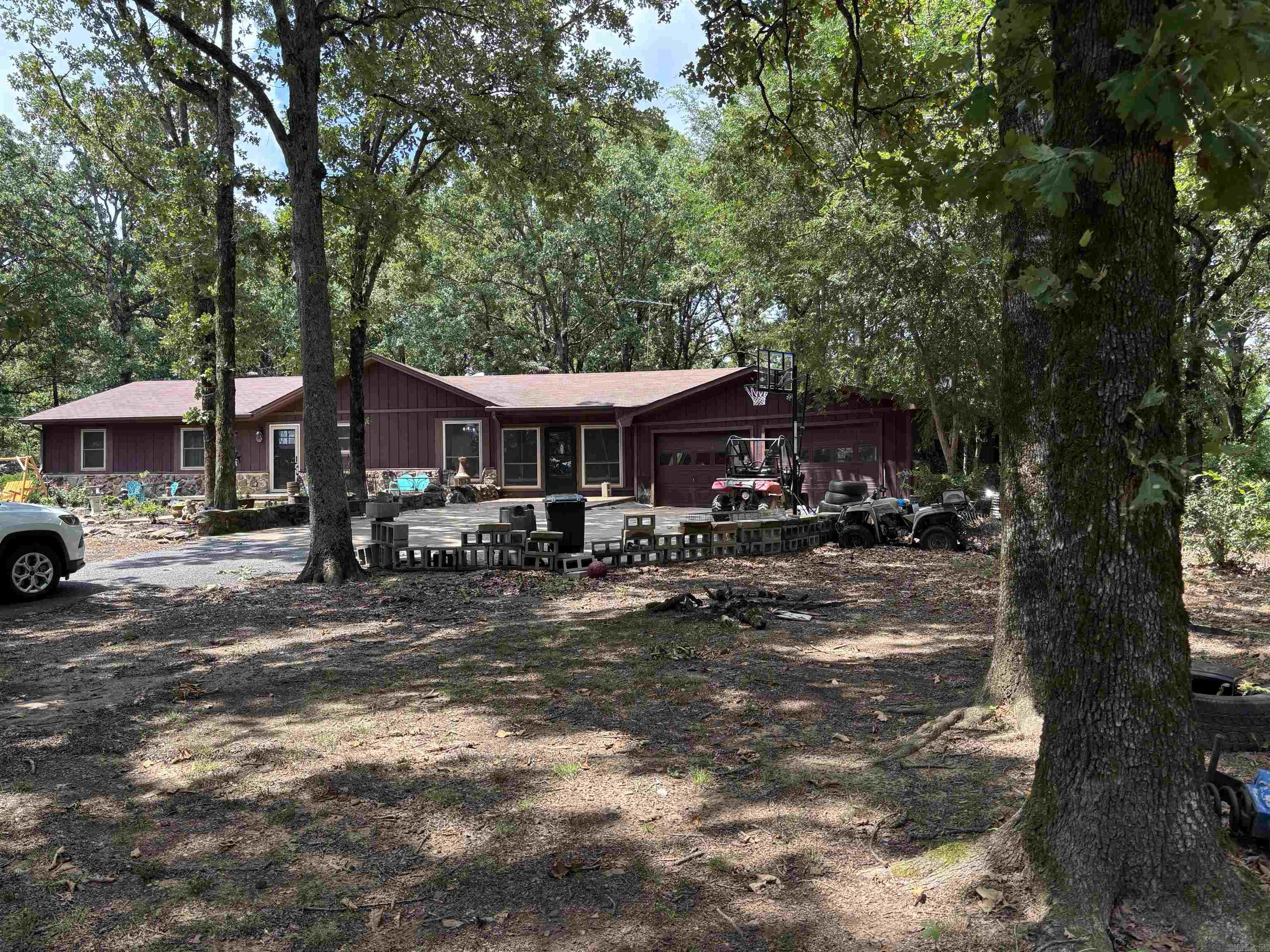 Set on approximately 8 acres of peaceful, tree-filled land, this inviting country home offers room to breathe, grow, and enjoy the outdoors. With 3 bedrooms and 2 bathrooms, the home features an open kitchen, dining, and living area that creates a comfortable flow for everyday living. The living space is anchored by a fireplace with gas logs, adding charm and warmth throughout the seasons.  An additional flex room expands the home’s possibilities — currently used as a bedroom, it could easily become a game room, family room, or home office, depending on your needs.  Propane is used for wall/heater in extra living space and the gas logs.    Surrounded by mature trees and wide-open acreage, the property delivers privacy, natural beauty, and the quiet rhythm of country living. Whether you envision gardening, hobby farming, outdoor recreation, or simply enjoying the peaceful setting, this land offers endless potential.  A welcoming rural retreat with versatile space and a beautiful natural backdrop.  *AGENTS SEE REMARKS*