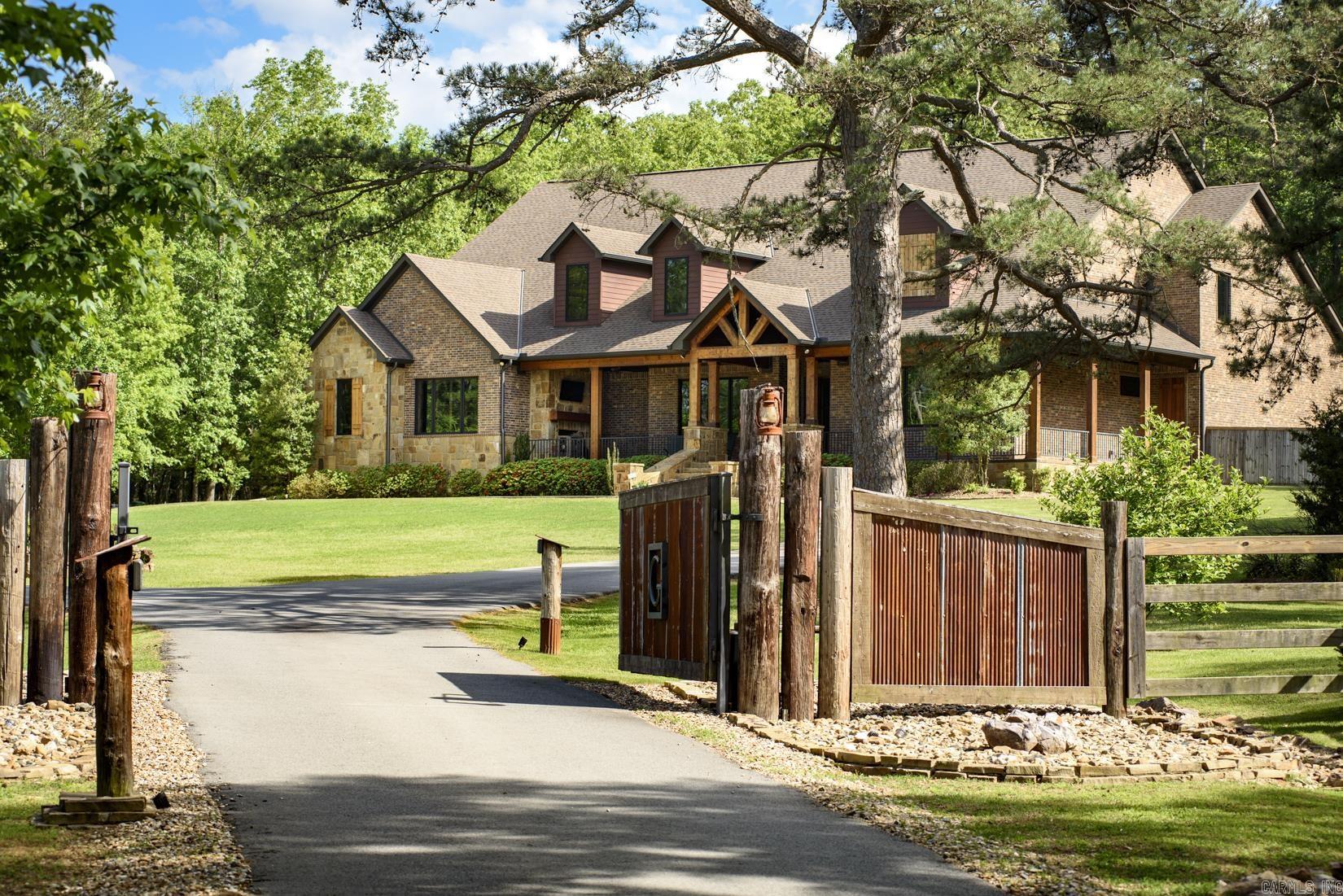 Experience refined lodge-style living in this exceptional custom home set on 5.05± private acres, masterfully built by Tim Hughes. Thoughtfully designed with craftsmanship at every turn, the interior features oversized solid wood doors, custom cabinetry throughout, and a dramatic stacked rock accent wall in the formal dining room. The open-concept living, dining, and kitchen spaces are ideal for entertaining, anchored by a chef’s kitchen with four KitchenAid Professional Series ovens, a gas range with griddle, and abundant storage. Specialty spaces include a library/office with cozy reading nook, a professional-grade theater room with a 200-inch screen and SVS sound system, a craft room with padded commercial flooring, and a fun bunk/sleepover room. Two laundry rooms, a dog washing station, and exceptional storage add everyday convenience. Outdoor living shines with a covered front porch featuring a fireplace, a spacious screened porch with outdoor kitchen, greenhouse, and ten raised garden beds. Additional highlights include a heated and cooled four-car garage and two whole-house generators—offering luxury, comfort, and peace of mind in a truly one-of-a-kind setting.