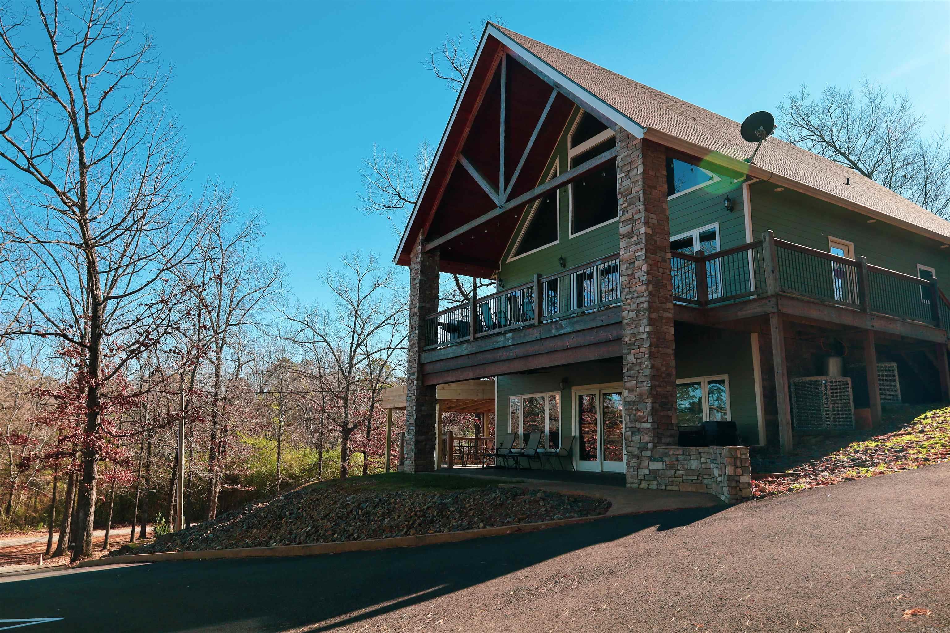 Lakefront/view condo w/boat slip to use when staying there! 2-Bed, 2-Bath, Approx 1,267 Sq Ft downstairs unit. Fully furnished w/stainless appliances, new adjustable base beds (2025), SMART TVs (2023), stacked washer & dryer, bar stools, couches, kitchen table, patio furniture, & more! Begin using & VRBOing this unit Day 1. Entering the home notice the open concept, the immaculate condition, the large stone fireplace, granite countertops, & more! Unit is VERY energy efficient! High Speed Fiber Internet is available & in place today. Upgrades such as under cabinet lighting, granite counter tops in kitchen & bathrooms as well as real hardwood floors & instant hot water too! The covered front porch boasts a custom concrete & stacked stone columns. This property also has a covered deck to the side w/ tongue and groove ceiling & more! This property is assigned Boat Slip 4 (Qty 1) & Parking Spots 4 Assigned (Qty 2) in the Bellawood Resort. Broker Owned Property. To retain use of the assigned boat slip you must also participate in renting out this unit as nightly rental “some” from April – Sep each year per Corp of Eng Regulations for Boat Slip Lease – See Agent Remarks & Assoc Docs.
