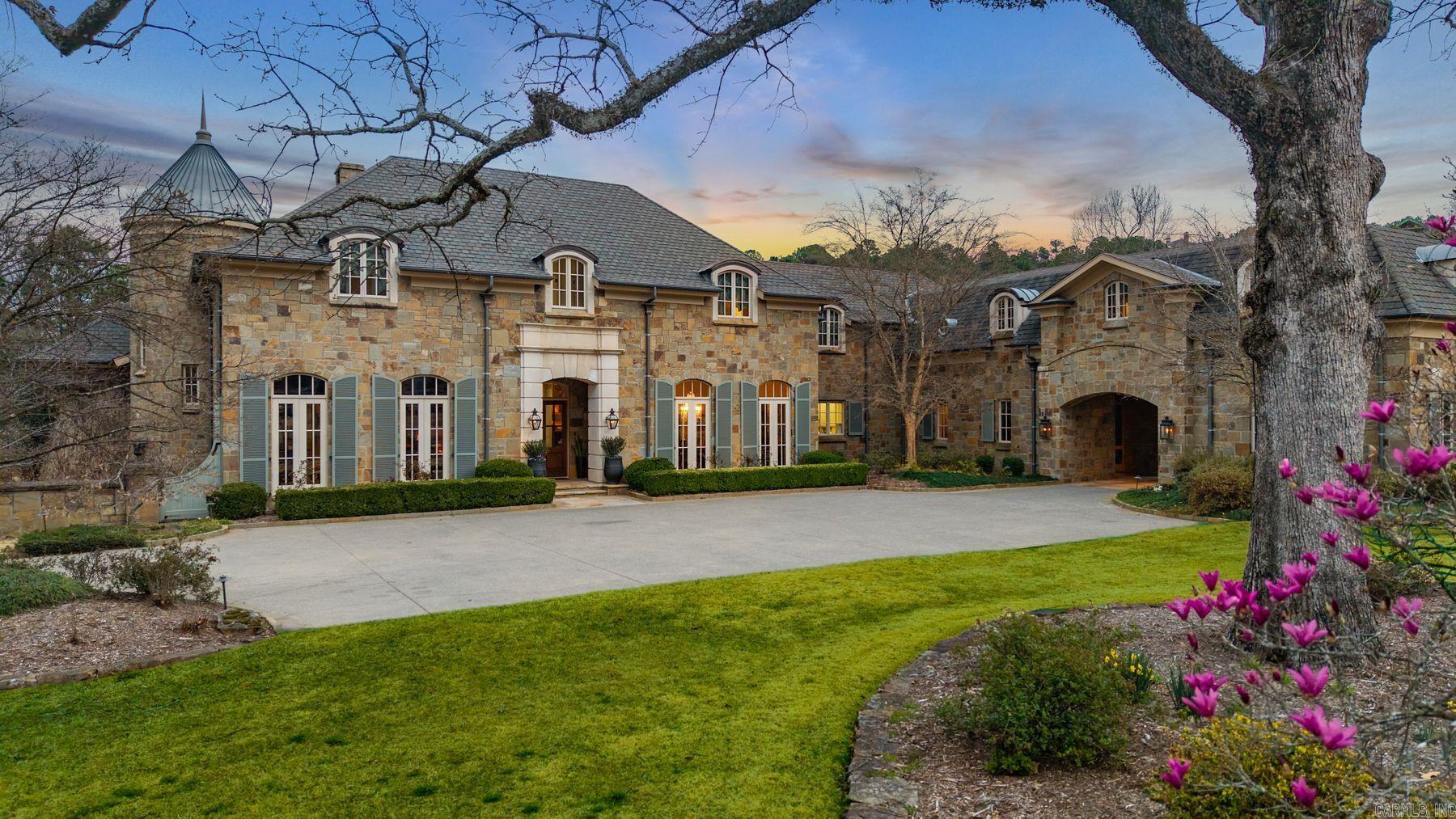 An exceptional European countryside-inspired estate set on a rare 1.78-acre double lot in Valley Falls Estates. A distinguished arrival begins with a motor court, porte cochère, and four-car garage. Timeless interiors showcase quartersawn oak hardwood floors and elegant marble, limestone, and granite finishes. A thoughtfully designed floor plan features five bedrooms, four full baths, two half baths, including two primary suites on the main level and one upstairs. The gourmet kitchen, centered around an oversized island and illuminated by a large skylight, flows seamlessly into the cozy hearth room with a gas fireplace and Dutch doors leading to a massive screened-in porch with a custom outdoor grill, creating effortless indoor-outdoor living. Additional spaces include a dramatic two-story living room, executive office with custom millwork & library ladder, game room, media room with storm-safe construction & expansive mudroom. Outdoors, a heated pool and spa, fire pit, & expansive covered patio with a gardener's prep area create a private retreat. This residence is an architectural statement designed for refined living.