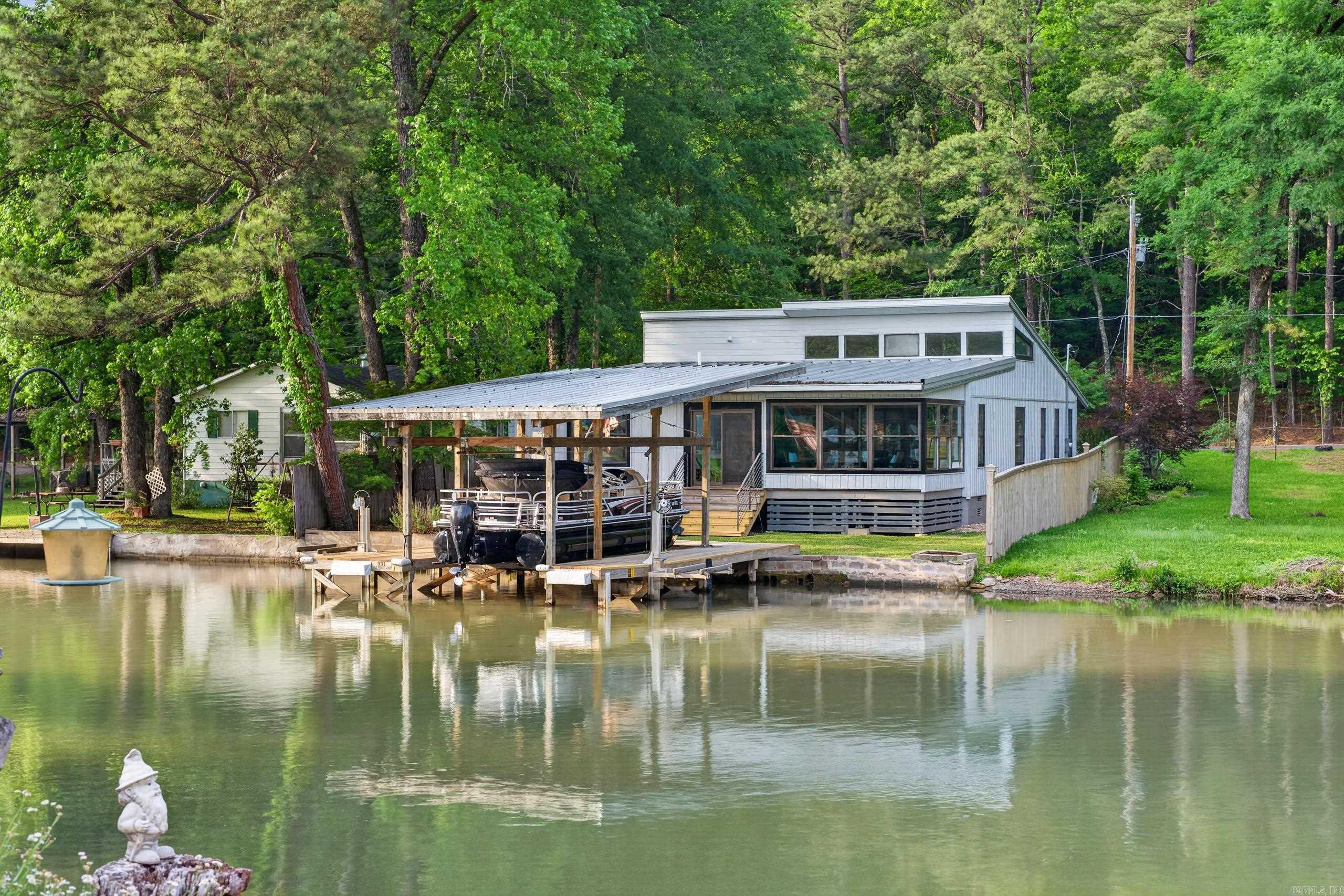 Lakefront living meets investment opportunity in this recently updated 3 bed, 3 bath home with 1,988 sq ft and 2-car garage in desirable Hot Springs Arkansas. This waterfront property features a private boat dock that includes a lift for the boat and two lifts for jet-skis; perfect for boating, fishing, and enjoying the lake lifestyle. Newly re-sided exterior adds fresh curb appeal and low-maintenance value. Ideal as a short-term rental, vacation home, or full-time residence with strong income potential. Inside offers an open floor plan, spacious living areas, and large sitting room/sunroom for your morning brew before hitting the lake. The updated kitchen flows seamlessly into the living and dining spaces—perfect for entertaining. Generous sized bedrooms, including a primary suite, provide comfort and privacy. Enjoy outdoor living with direct lake access, relaxing views and space to unwind. Conveniently located just minutes from downtown Hot Springs full of dining, shopping, Oaklawn, and local attractions like Bath House Row. Rare opportunity to own a lakefront home with dock, 2-car garage, modern updates, and investment potential in a convenient location.