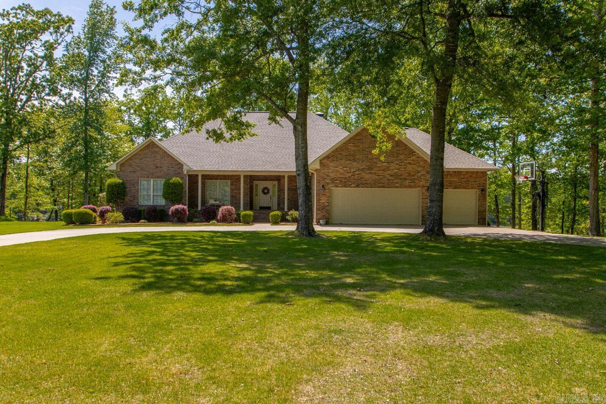 Lakefront luxury in this stunning 2.14-acre estate located within the Springlake Country Club Estates, in the heart of the East End community, just 15 minutes from downtown Little Rock. This beautifully updated home welcomes you with a grand entryway that leads to a versatile large office or fifth bedroom, transitioning seamlessly into an expansive open-concept living area featuring a fireplace, custom cabinetry, and a gourmet kitchen designed for large family gatherings. The thoughtful split-bedroom floor plan ensures maximum privacy, massive primary suite with full bath and walk-in closet, while the opposite wing houses three spacious guest bedrooms with a large hall bath, and an additional half bath. Storage is effortless throughout with oversized closets and a generous three-car garage, but the true highlight lies outdoors: a humongous dual-level back deck—offering both covered and uncovered sections—overlooks the serene lake and your vast private acreage. Whether you are enjoying your morning coffee during a quiet sunrise, launching a boat from your own backyard, or hosting a sunset dinner, this property offers a rare blend of space, style, and resort-style living. See Remarks