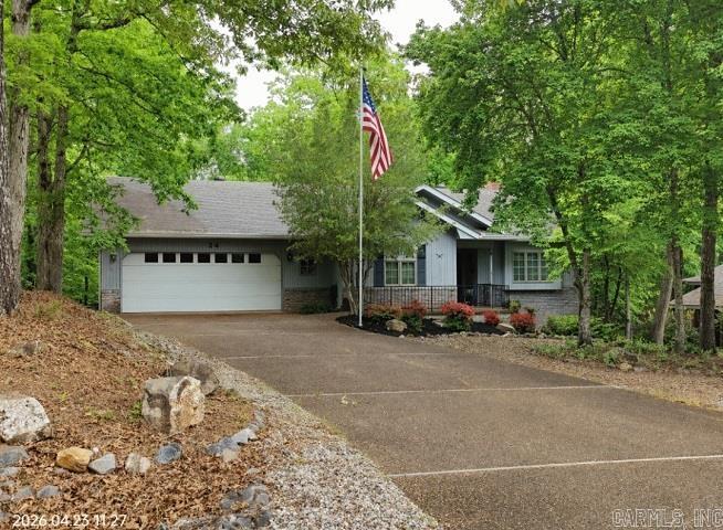Lovely, inviting front welcomes you to an immaculate, well-maintained interior. This three-bedroom, two-bath ranch features a vaulted ceiling in the great room with two skylights, built-in shelving and cabinets surrounding a wood-burning fireplace. The living area opens to a beautiful Arkansas room full of windows and overlooks the woods and fenced yard. The kitchen features built-in double ovens, microwave, granite counters, ceramic backsplash, and pantry. The dining area’s bay window looks out over a beautifully wooded lot. The primary suite boasts two closets, level walk in shower & access to deck. Spacious guest rooms are separate from the primary suite. Conveniently located, the laundry room is just off the kitchen. The oversized garage has a workbench and is large enough to hold your F-150. Handicap-accessible entry doors include a small ramp and doors wide enough for a wheelchair.  The Village is a 26,000-acre gated community with 11 lakes, 9 golf courses, pickle ball, tennis, 40 miles of hiking trails, indoor and outdoor pools, fitness center, two marinas and white sand beach with covered picnic tables, fishing pier, volleyball and playground. .