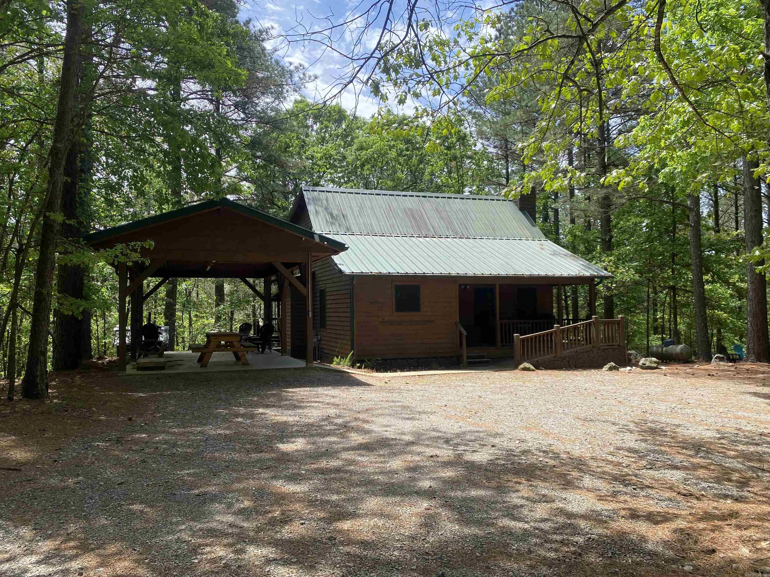 Don't miss out on this wonderful opportunity!  Own your own vacation cabin so you can enjoy Lake Ouachita and all the natural beauty in the area, while still producing income when you are not using it. Located in Woodland Springs subdivision and only 20 minutes to Hot Springs, this 1274 square foot cabin home is surrounded by lush trees on 4.81 acres more or less. There are two regular bedrooms and also a sleeping porch for extra guests to visit. Wood floors in all the main living areas with tile in the two full baths. On the back of the house, there is a large covered deck for entertaining. Property is selling mostly furnished, so all you have to do is come when you close!  Call today to set up an appointment.