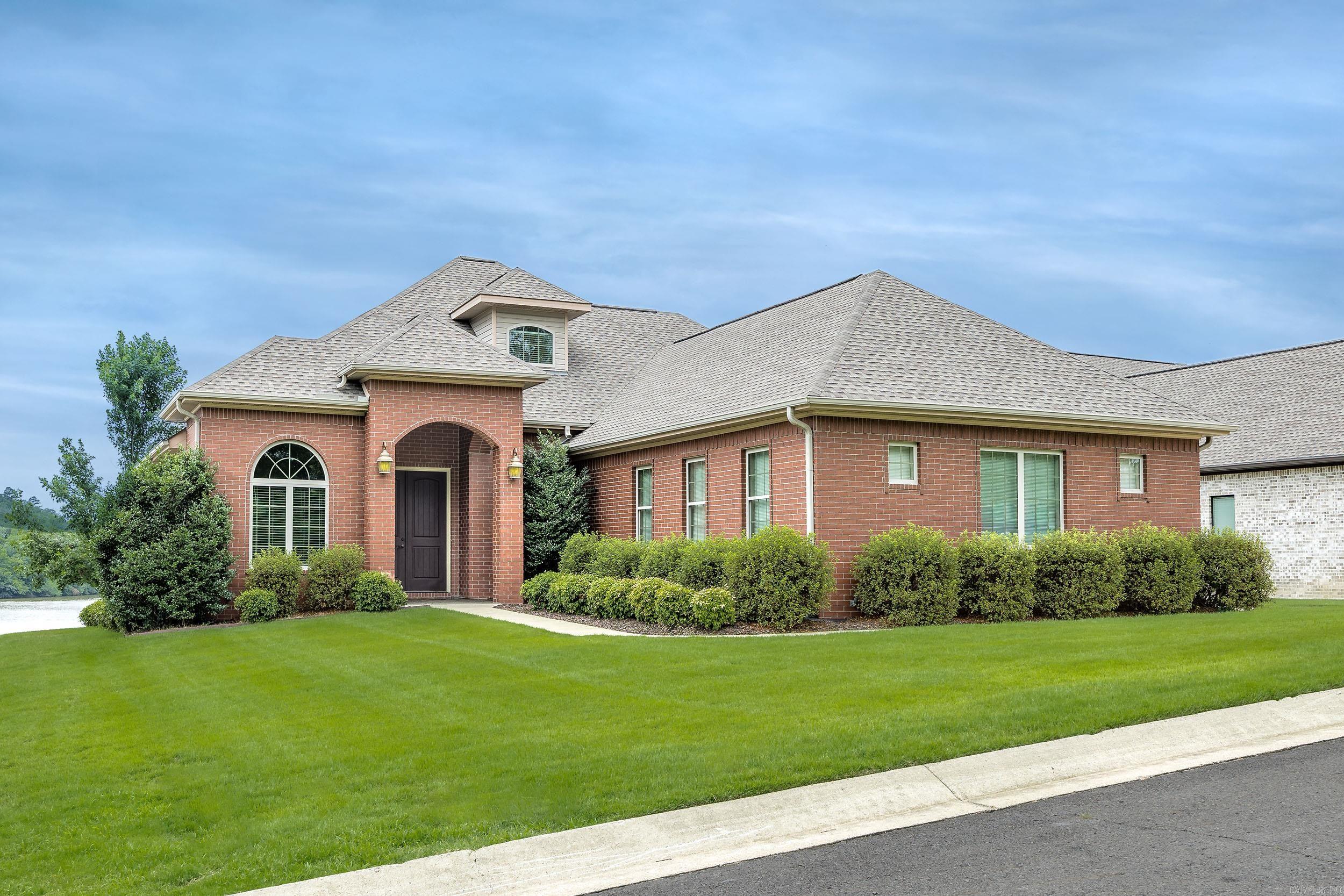 Welcome to this exceptional waterfront home where luxury, comfort and natural beauty converge. Perfectly positioned to capture breathtaking sunsets, this impeccably maintained 3,713 sq ft residence offers effortless elegance in a desirable gated community. Step inside to soaring 11-foot ceilings and an open-concept design that seamlessly connects the formal dining and living areas, creating an ideal space for entertaining. The gourmet kitchen features granite countertops, custom cabinetry, a built-in oven and microwave, and a separate cooktop, blending style with functionality. The main level features elegant porcelain tile flooring throughout, along with three spacious bedrooms and two and a half baths. Upstairs, a private guest suite includes its own bath and comfortable sitting area, providing a peaceful retreat for family or visitors. A rare four car garage offers abundant space for vehicles, lake toys and storage. Outside, enjoy the best of lakefront living from the covered patio, overlooking beautifully landscaped grounds that gently slope down to your private two-slip boat dock, with a lift for each slip. Experience stunning sunsets and the ultimate waterfront lifestyle.