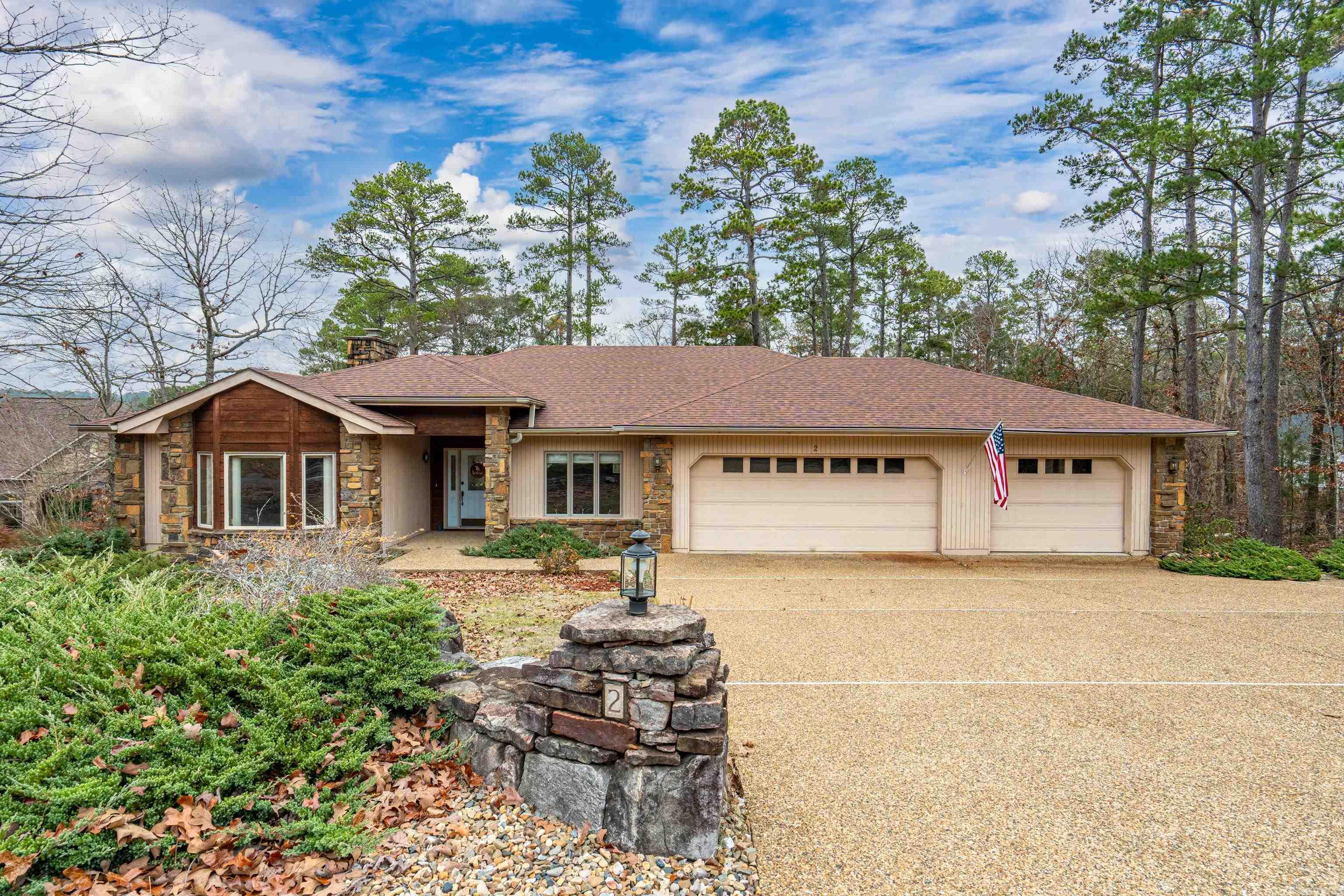 This distinctive 1 owner home offers an exceptional blend of comfort and space. The main level features generous living areas highlighted by a wood-burning fireplace and a large enclosed porch and deck that capture the beauty of the natural surroundings. The lower level includes a bedroom, full bath, and private living space with separate access, ideal for guests or multi-generational living. the coveted three-car garage provides abundant storage and room for lake or golf equipment. Thoughtfully designed and full of character, this home offers endless possibilities to enhance and modernize while enjoying the prestige and tranquility of Hot Springs Village. Perfect for those seeking privacy, space, and proximity to the lake. Seller paid buy-in fee!