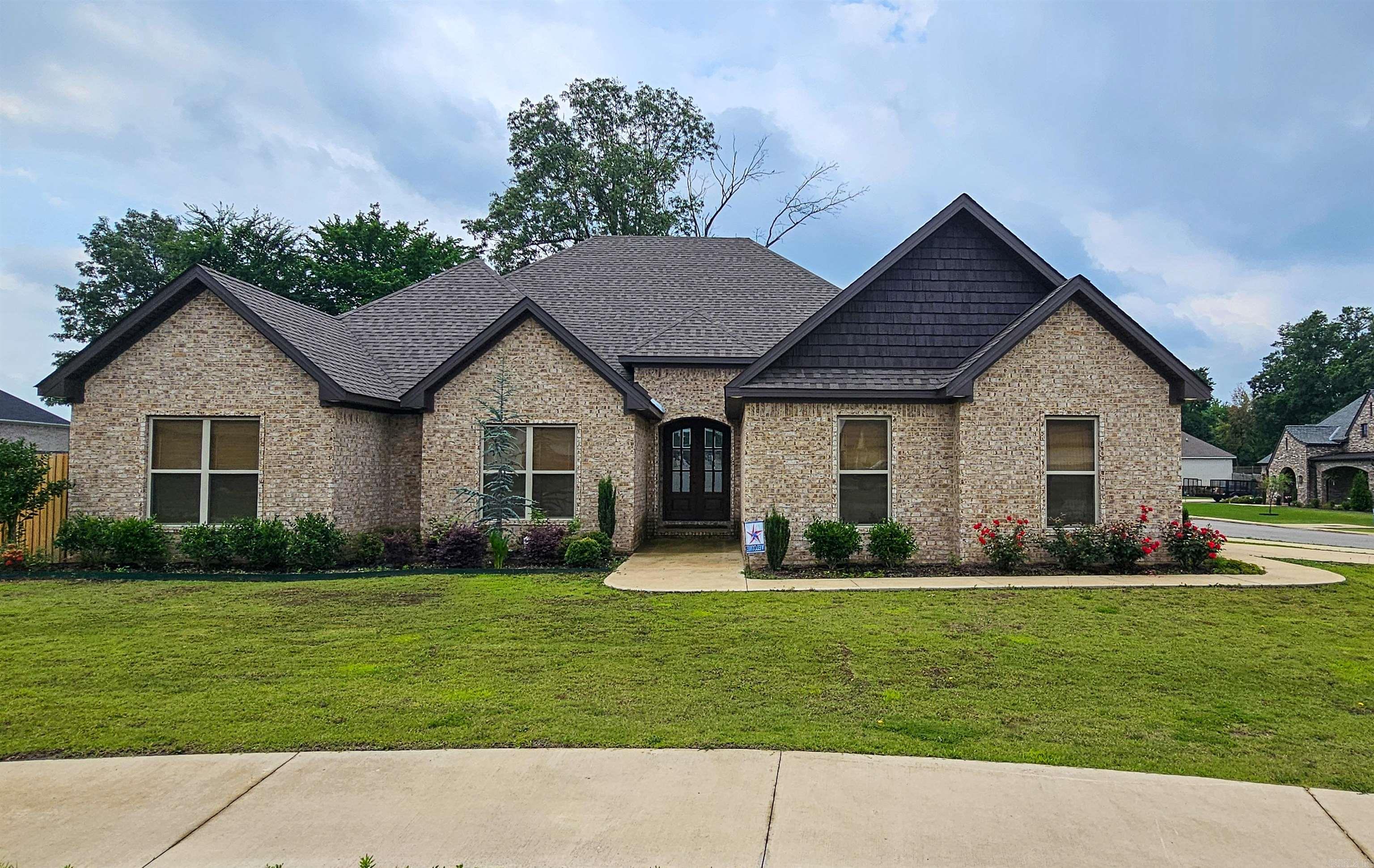 Introducing this exquisite one-level brick home, hitting the market for the first time with over 2,500 sq. ft. of sophisticated living space. Luxury vinyl flooring is found throughout except in the baths that have ceramic tile. A wide entryway welcomes you into a spacious great room, highlighted by built-in shelving and a warm gas-log fireplace. This flows effortlessly into a modern kitchen and dining combo, equipped with solid surface countertops, a large pantry, abundant cabinetry, and an expansive breakfast bar/island—ideal for entertaining. The Primary Suite is a true retreat, featuring a luxurious bath with dual vanities, a freestanding tub, a separate oversized custom-tiled shower, and an exceptionally large walk-in closet. Three additional bedrooms provide ample space and large windows for natural light. The home also includes a convenient laundry room, a full bath, and a guest half bath. Unwind on the screened sunporch, perfect for enjoying rainy days or sunny afternoons in your private, wood-fenced backyard. Located on a generous lot in the Brookland School District.
