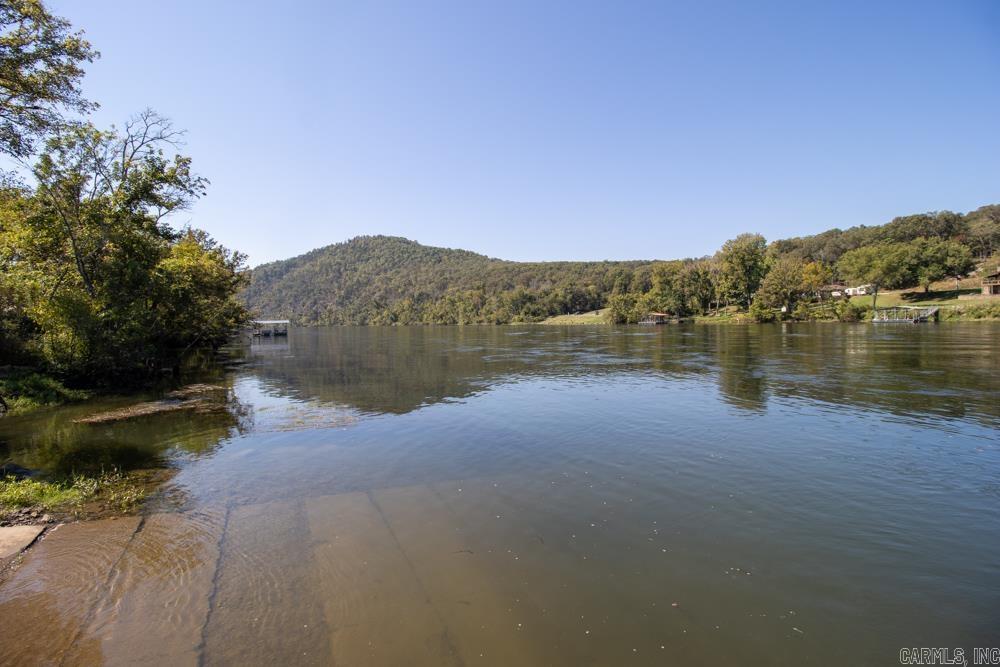3.9 Acres Overlooking the White River – Mountain Home, AR  This 3.9-acre bluff-top property offers a mix of hardwood timber and rock outcroppings with a single building site positioned for sweeping views of the White River valley. Located in a quiet, well-kept river community, owners have access to a private boat launch, use of a community clubhouse, and benefit from protective covenants with an annual HOA.  Utilities are available; septic system required. Just minutes from Cotter, Arkansas—known as the Trout Capital of the World and home to a 38 lb. 7 oz. record brown trout—plus Norfork Lake, Bull Shoals Lake, the Buffalo National River, and nearby access points at White Hole, Wildcat Shoals, Roundhouse Shoals, Rim Shoals, and Buffalo City.