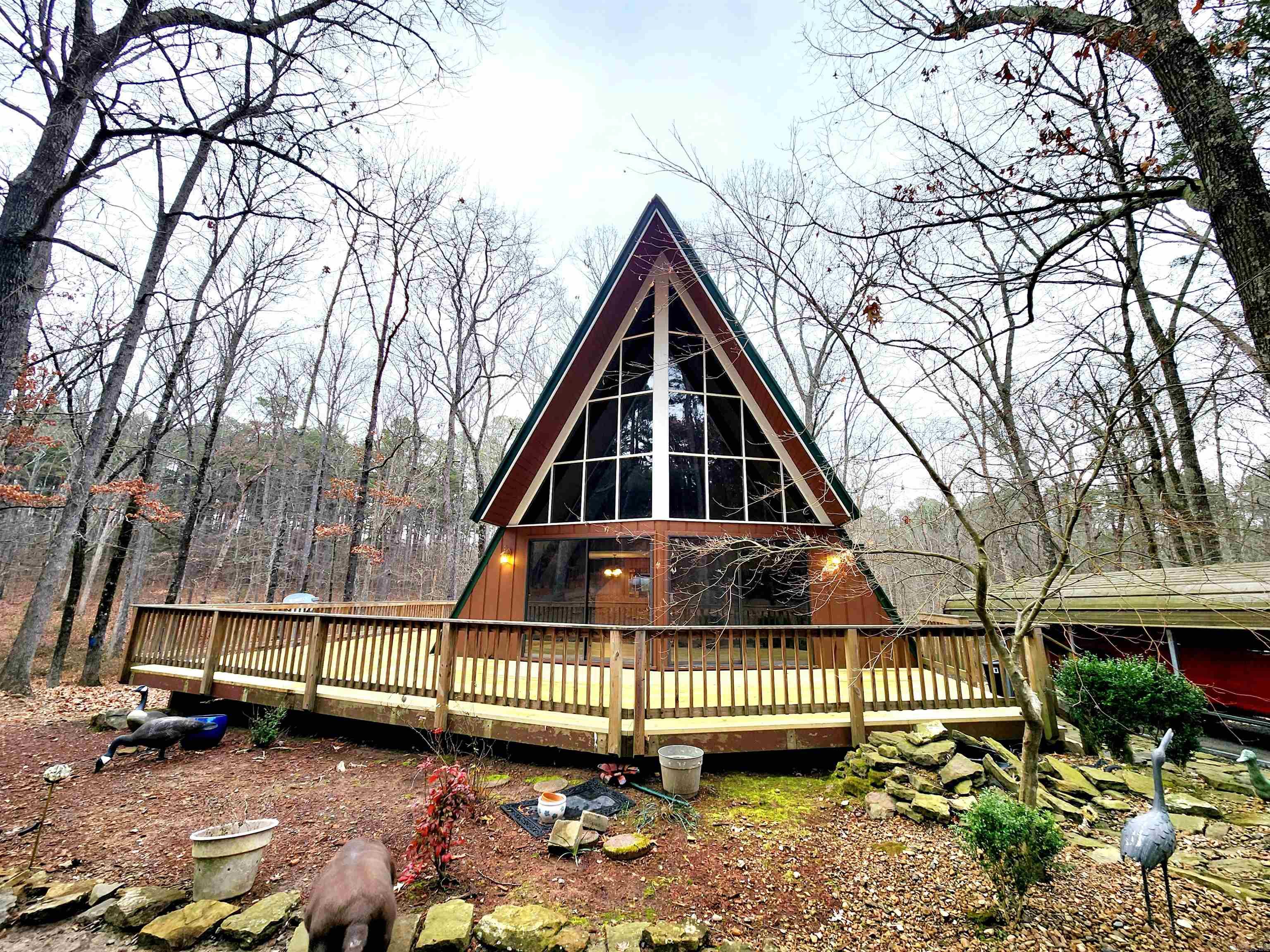 Surrounded by an abundance of trees, the property is a nature lover's paradise. The dense foliage not only ensures privacy but also creates a haven for local wildlife. It's not uncommon to spot deer and turkey roaming freely, adding to the charm of this rural retreat. The home features a wood fireplace, perfect for those chilly winter nights. The house comes with a generously sized deck, offering an ideal spot to unwind and soak in the natural beauty of the surroundings. The distinctive A-frame structure not only gives the house its charming character but also allows for high ceilings and large windows, ensuring plenty of natural light and stunning views of the surrounding landscape.