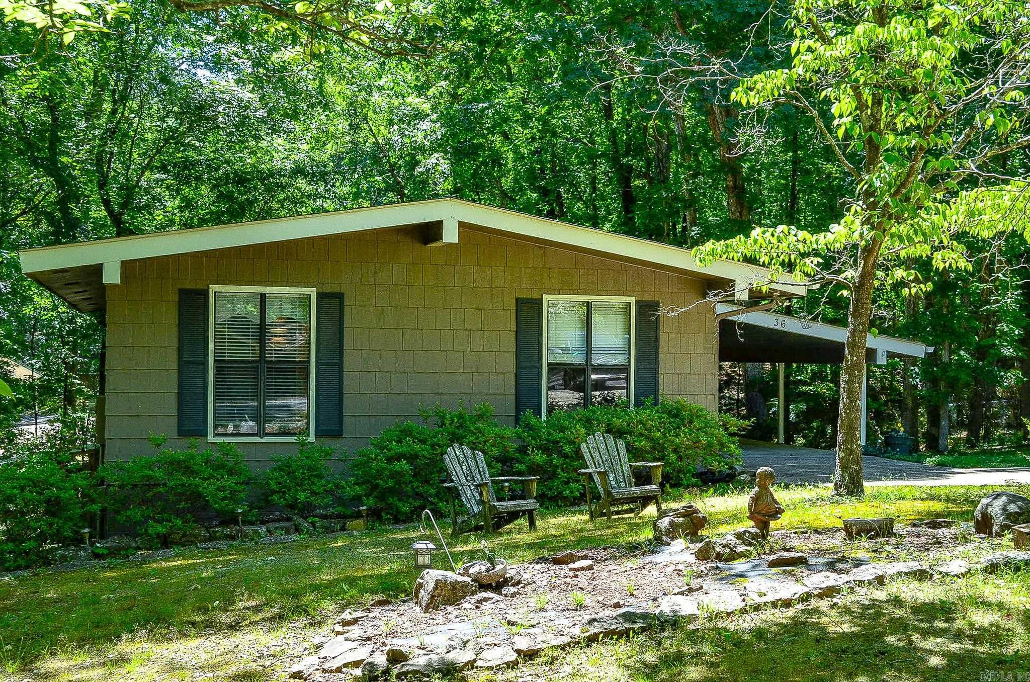 Surrounded by mature trees and peaceful natural scenery, 36 Cambre Circle offers the kind of relaxed Hot Springs Village lifestyle buyers dream about. From the moment you step inside, oversized glass doors and expansive windows draw your attention to the beautiful wooded setting while filling the home with natural light.  The spacious open layout creates an inviting atmosphere perfect for quiet evenings at home or gathering with family and friends. The oversized deck extends your living space outdoors, creating the perfect place for morning coffee, outdoor dining, or simply enjoying the privacy and tranquility of the surroundings.  Inside, you'll find updated flooring, generous living spaces, and a bright kitchen with abundant cabinetry and workspace. Conveniently located near golf courses, lakes, walking trails, and Village amenities, this single-family home is ideal for full-time living, a weekend retreat, or a low-maintenance getaway in Hot Springs Village.  First time HSV Buyers are responsible for the one-time $2,000 new member fee payable at closing.  Agents kindly review agent remarks.