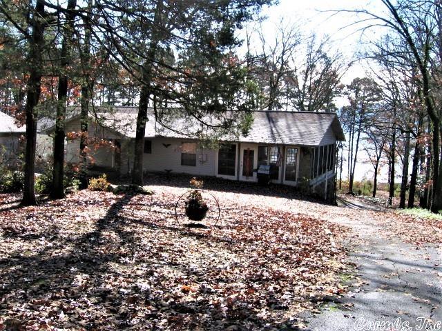 LAKEFRONT HOME WITH 3000 SQ. FT.  Great for multi-family use!!!  Two levels, each with 1500 sq.ft., two full kitchens  & living areas.  Lower level originally designed as in-law qtrs. with private entrance.  Main level: 2 BR, 2Ba, huge living-dining combo, f/p, kitchen, w/d hookups, sunporch.  Lower Level:  2 BR, 1.5 Ba, huge open  kitchen, living & dining area, f/p. All very well-built with poured concrete foundation. Lg. garage/storage.  PLUS detached garage, a det. storage shed/carport, another carport for boat, ATVs, etc.  Nice paved circular driveway.  Has private well, but also central water.  POTENTIAL PLUS!!!!  Needs cosmetic updates throughout, plus decks. House is used as a short-term rental, sleeps 10-12.  Easy walk to water's edge to swim, sit on the beach area or hop in a boat!  Price includes two wooded lots across the street (1 ac. each). Subdivision plat map available.  A great lakefront package for an extended family, corporate or rental use.  Just make it yours with updates, and they will come.  Great view of water.