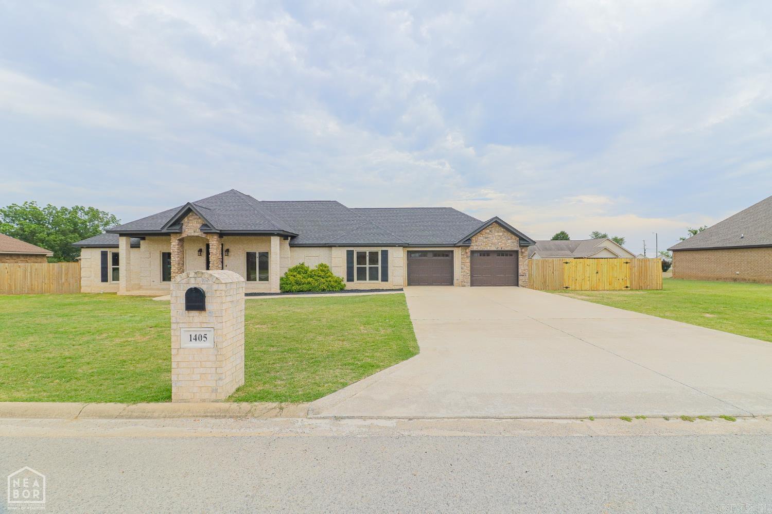 Welcome to 1405 Bart Street in Lake City, located in the Riverside School District. This well-maintained 3 bedroom, 2.5 bath brick home with stone accents offers 2,088 sq. ft. of living space on a 0.46-acre lot, complete with an attached dual-bay two-car garage. The split floor plan features a primary suite with separate tub and shower, dual-sink vanity, walk-in closet, and a bonus room ideal for a nursery, office, or sitting area. Each additional bedroom has a walk-in closet, and the home offers excellent storage throughout, including a walk-in hallway storage closet, decked attic storage, and a reinforced safe-room closet. The separate laundry room includes cabinetry, sink, and additional storage. Interior features include fresh paint, new carpet, solid wood cabinetry, granite countertops, and ceiling fans. Roofs on both the home and outbuilding are 3 years old. Natural gas heat, water heater, and cookstove add efficiency and convenience. Move-in ready with thoughtful features, abundant storage, and small-town living just minutes from Jonesboro.