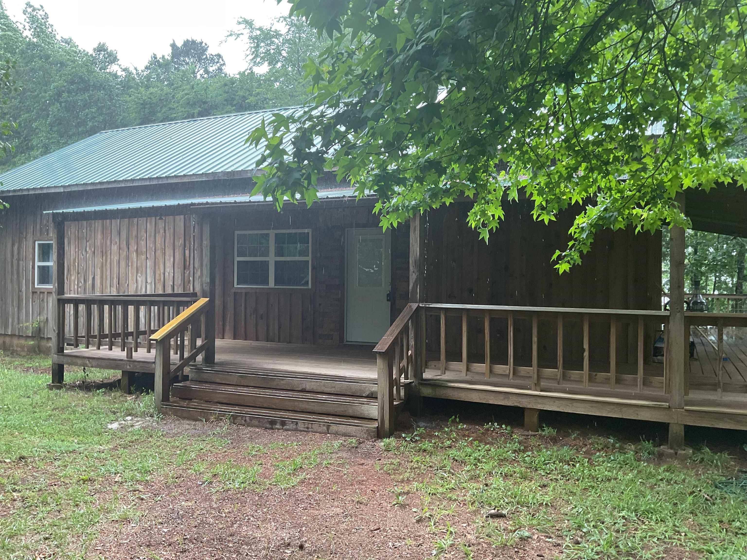 LAKEFRONT CABIN WITH 2 STALL PRIVATE DOCK & approx. 242 feet of lakefrontage. What a fantastic setting with a gentle walk to the dock (northern end of property) & amazing rock formations (southern end). Privacy and total happiness are another two things you will have along with this rustic home featuring 3 covered porches & a sun deck.  Inside you will find an open floorplan, 2 bedrooms (separated), 2 baths (both with walk-in showers), large kitchen (with breakfast bar) & a washer/dryer pantry. You can walk to the Circle Acres launching ramp.