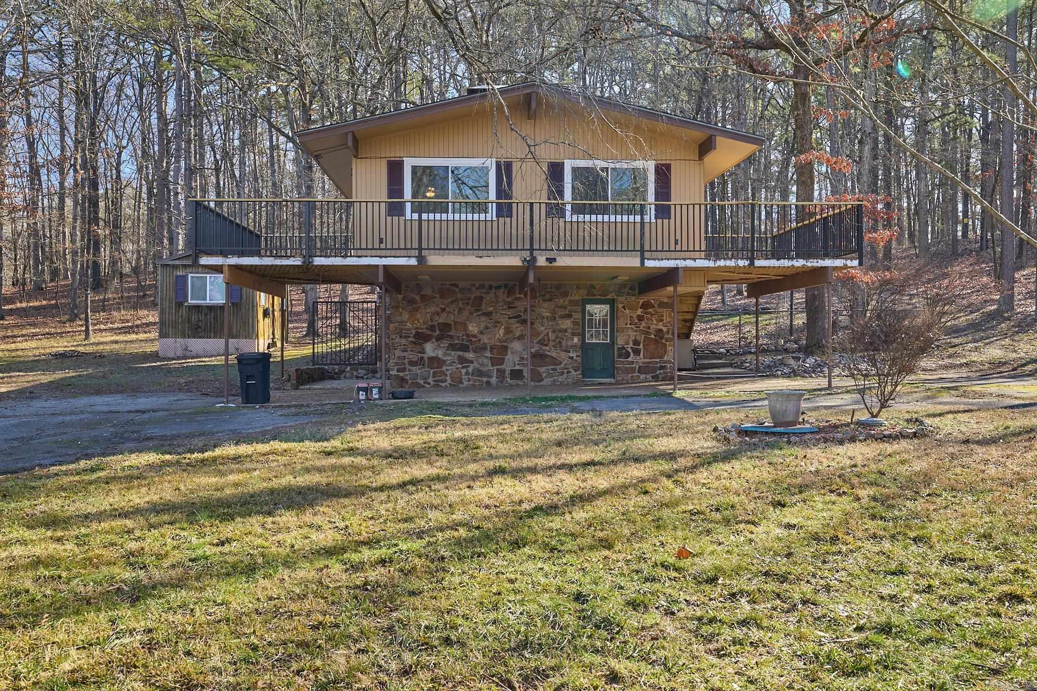 Welcome to your dream home nestled in the trees.  This remodeled residence offers the perfect blend of modern and comfort.  This Three Bedroom, Two Bath Home Features, a Modern Kitchen, Sleek Counter Tops, Spacious Cabinetry.  The Living Area Offers Vaulted Ceilings with a Massive Stone Fireplace.  The Master Suite is Located on the Second Floor for the Perfect Retreat.  Everyone will love the Expansive deck that wraps around the front and side of the home, perfect for entertaining and a great outdoor oasis.  The outside offers a nice storage building and a great fenced yard for any pets.  Home backs up to the State Park,  Your backdoor neighbors will be an abundant of wildlife.  Call today for a showing!!