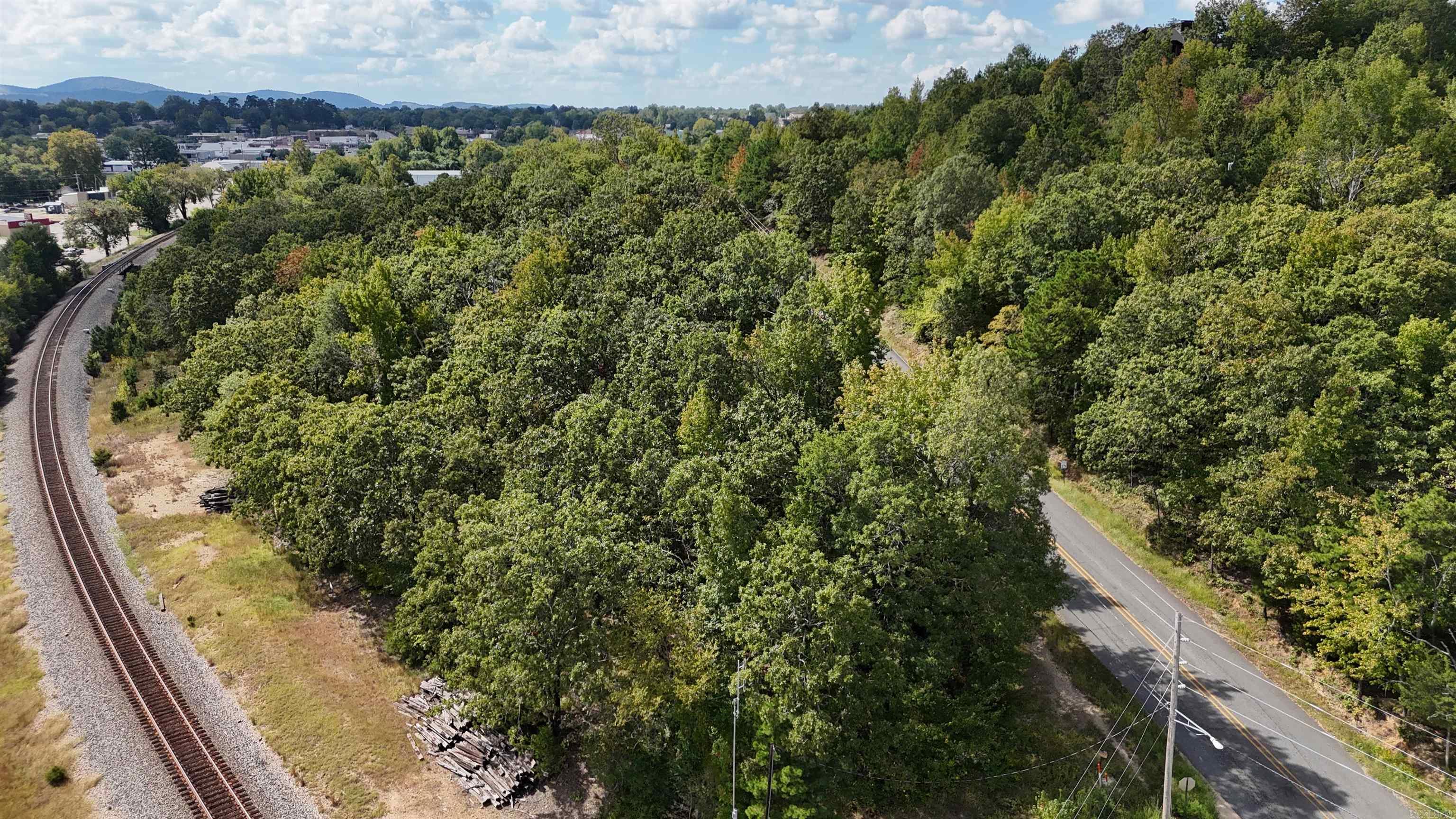 Commercial potential subject to appropriate zoning and approvals. Property overlooks portions of Mena and includes a creek that runs along or corners part of the tract. Buyers should verify current zoning, possible changes, access, utilities, and intended use with the city and county planning authorities.