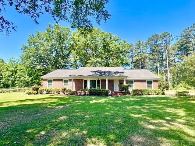 Beautifully maintained brick traditional home offering timeless charm, quality craftsmanship, and modern updates in a desirable quiet neighborhood close to all city amenities. This spacious 3BR/2BA home features an updated kitchen, two inviting living areas, and a formal dining room perfect for entertaining. Charming original details and rich woodwork add warmth and character throughout, while the cozy wood-burning fireplace creates the perfect gathering space. Step outside to enjoy the brick-covered patio overlooking the large partially fenced yard, ideal for relaxing or outdoor activities. Additional features include a 2-car carport with attached storage room and plenty of space for everyday living. A rare opportunity to own a classic home with enduring style and exceptional comfort.  Call today before this beauty is gone! Lot size, acreage, & square footage taken from courthouse records.