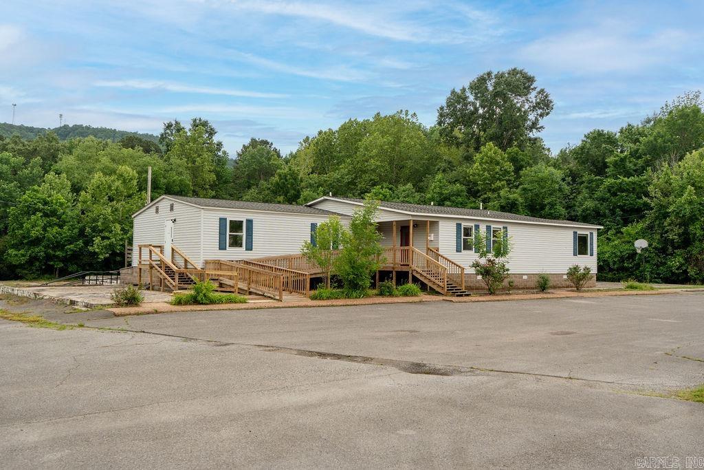 High-visibility commercial opportunity in Heber Springs, Arkansas, located at 817 E. Hwy 110 (Wilburn Rd), just 1 minute from the center of town. This versatile 3.3-acre property features approximately 2,400 square feet of professional office space with an impressive 425 feet of highway frontage for maximum exposure. The building offers a welcoming main entry/foyer, five private offices (two smaller and three larger offices that could also serve as conference rooms), three restrooms, a spacious kitchen, and washer/dryer hookups. Nearly an acre of paved parking in both the front and rear provides ample space for clients, employees, large equipment, or business vehicles, with additional room for future expansion. The flexible layout makes this property ideal for a wide range of businesses, including professional offices, medical, educational, daycare, or service-based operations. Surrounded by attractive park-like grounds, this well-maintained property also features a new roof installed in 2024 and HVAC updated in 2020.