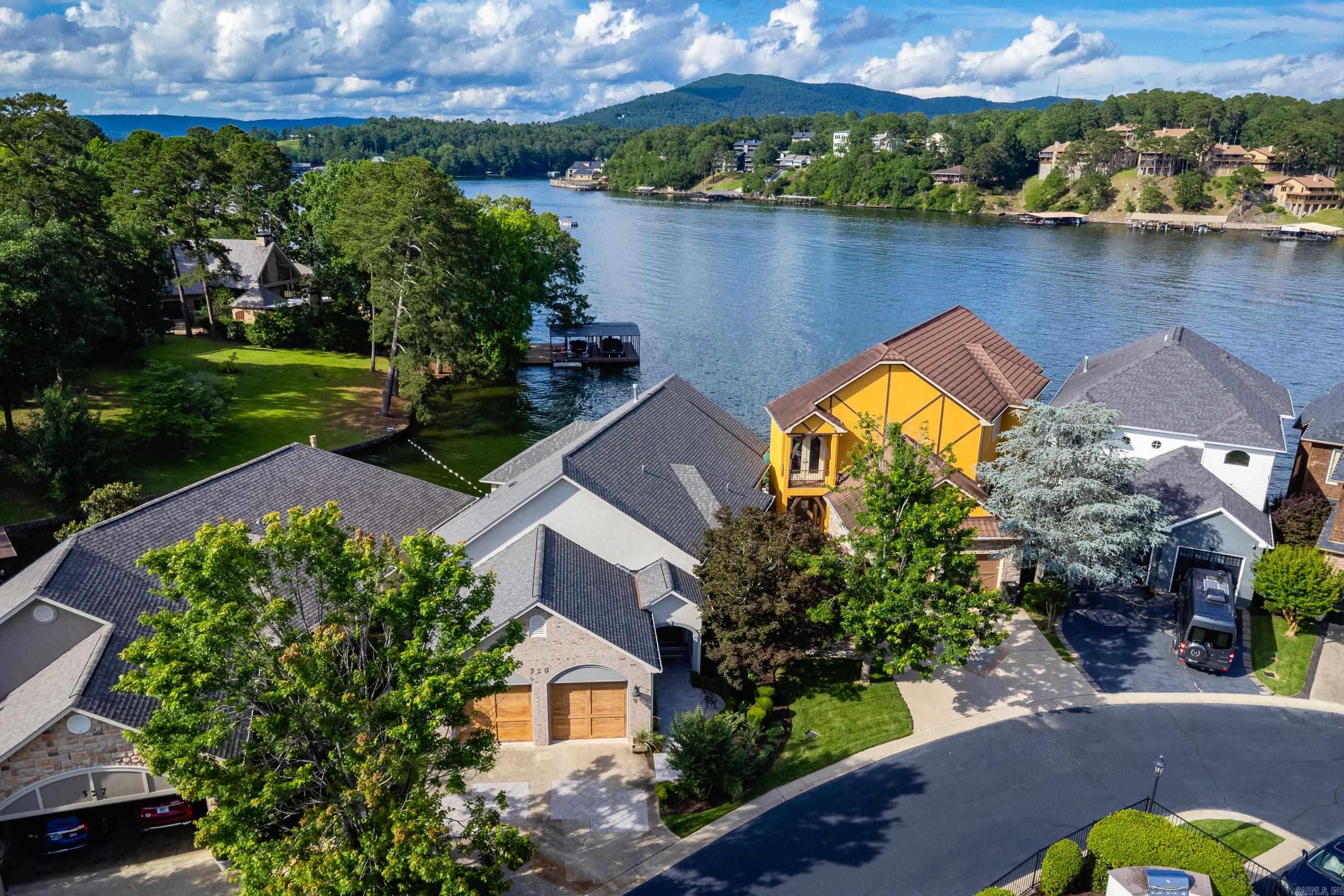 Lakefront living at its finest—just in time for summer! This beautifully renovated, move-in-ready home offers 3 bedrooms, 3.5 bathrooms, and breathtaking water views from nearly every angle. The bright, open floor plan features vaulted ceilings, a spacious living and dining area, a breakfast bar, wet bar, and abundant cabinetry for storage and entertaining. The primary suite is a private retreat, complete with a generous walk-in closet, luxurious bath, and a cozy sitting area framed by a picture window overlooking the lake. Start your mornings with coffee in the sunroom or unwind in the evenings on the back deck while taking in spectacular sunset views. With its private dock, stylish updates, and prime location, this exceptional lakefront property is ready for you to enjoy all season long.