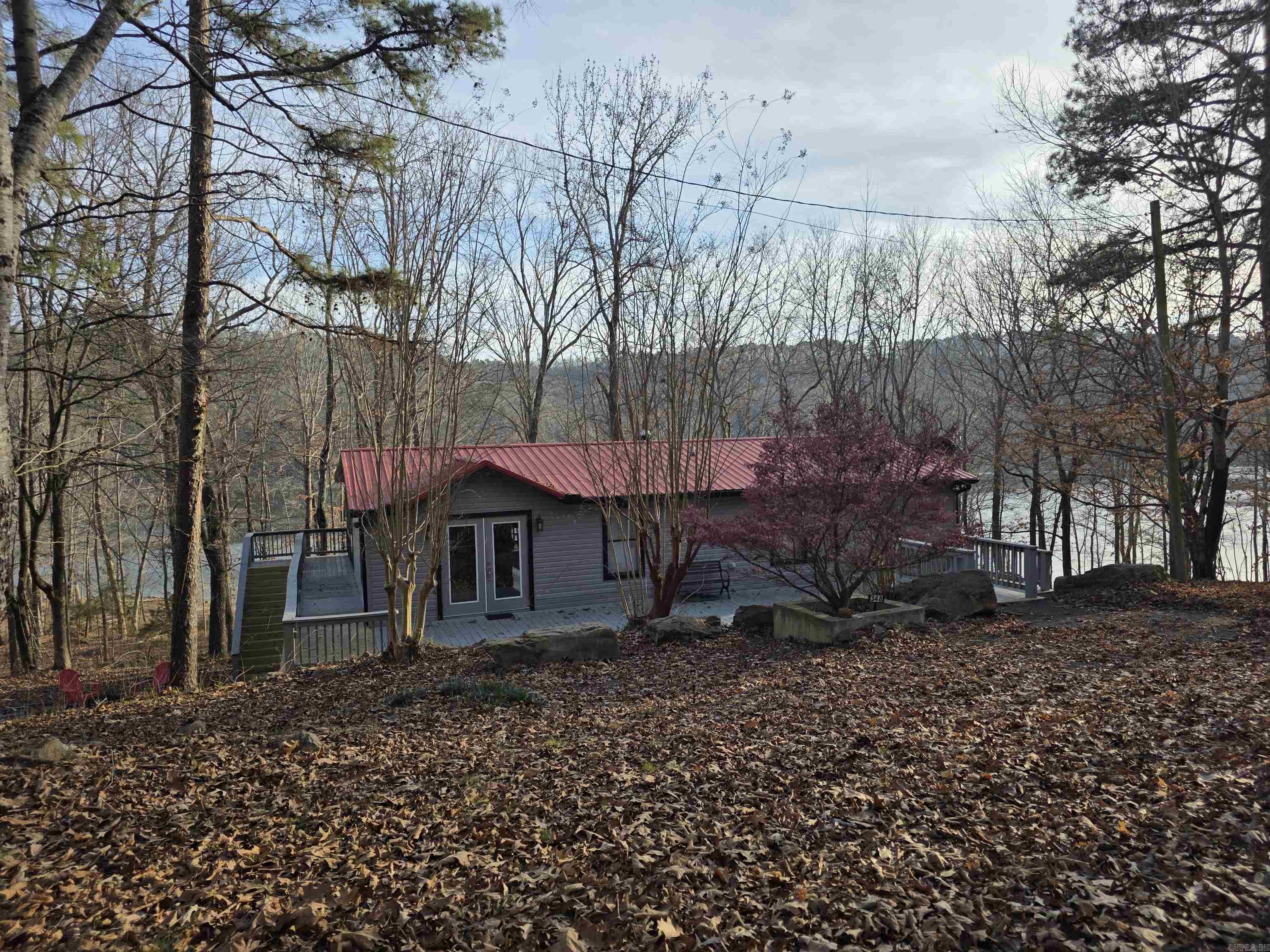 This lakefront opportunity does not come around often! Very very easy walk to the water from your back yard. Being able to have this view and easy walk is a very sought after thing around the Greers Ferry Lake area. Bring your clothes and toothbrush to this one and you are ready for your lake experience. All furnishings will stay to include bedding and even extra linens in every bedroom closet. Most artwork are one-of-a-kind pieces and bring a very tasteful decor to the home. There are 2 bedrooms on main level with one having an ensuite bath. Both bathrooms upstairs have jetted tubs. Downstairs you will find a kitchenette, open living space, and 2 more bedrooms and 1 bath. There are 5 outside doors downstairs. Each bedroom having their own door to outside. Safe room downstairs with access door from either inside or outside. Square footage measurement encouraged.