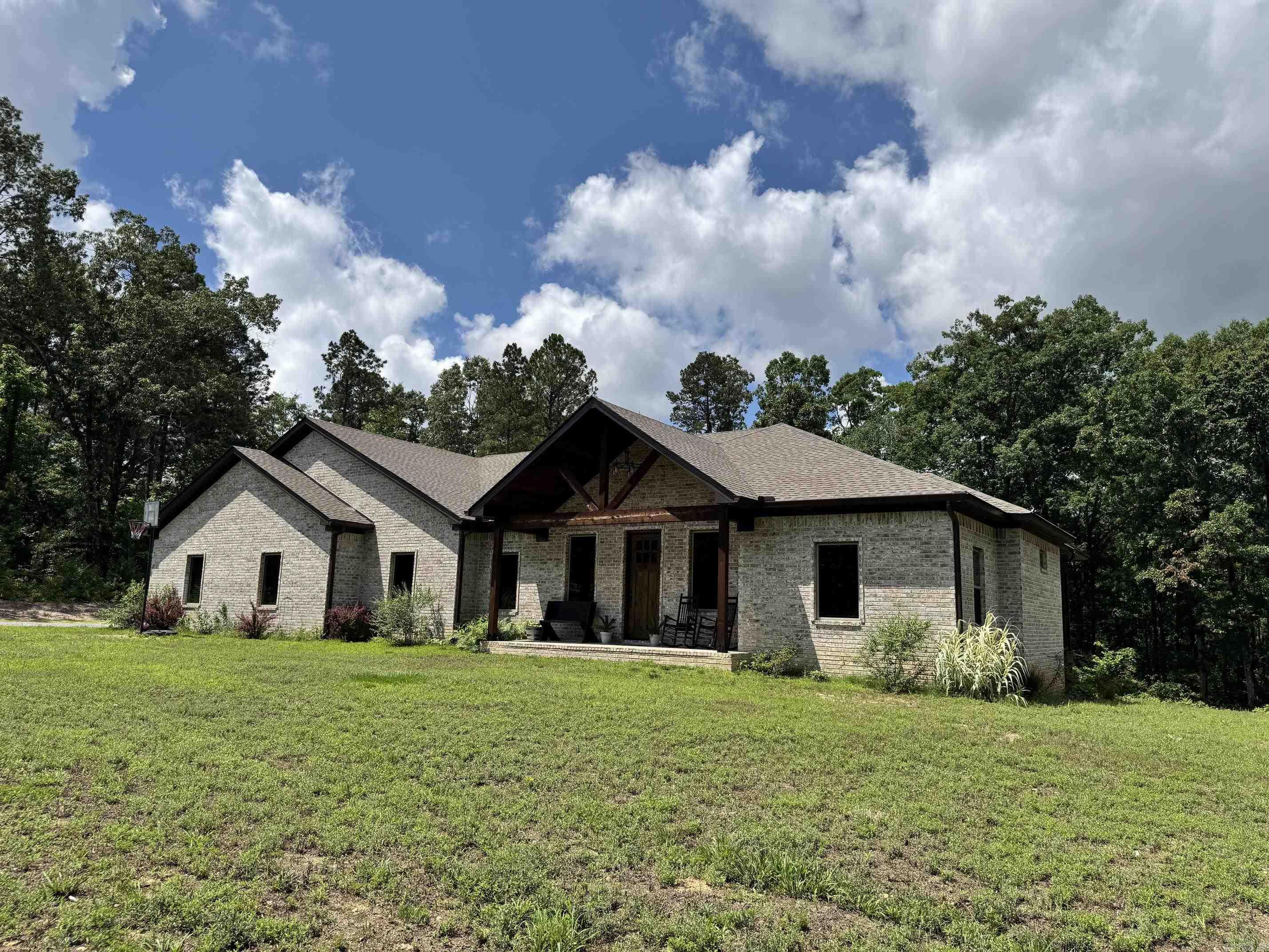 A private tree line surrounds this 1.38 acre country home in Glen Rose school district. 4 Bedrooms and 2.5 Baths in 2367sf;  Welcoming covered front porch, vaulted living room ceiling in an open layout; Kitchen has large granite island, farmhouse sink, SS appliances, with a hidden pantry!  There's a separate office that could be 4th BR.  Large master BR and private ensuite with rain-head in a beautiful tile shower & freestanding tub. Large covered back deck leads into spacious private back yard.  Also check out the safe room in master closet! Built in 2023 with all brick exterior. City water with septic, outside city limits yet surrounded by other beautiful homes. Schedule your showing today.