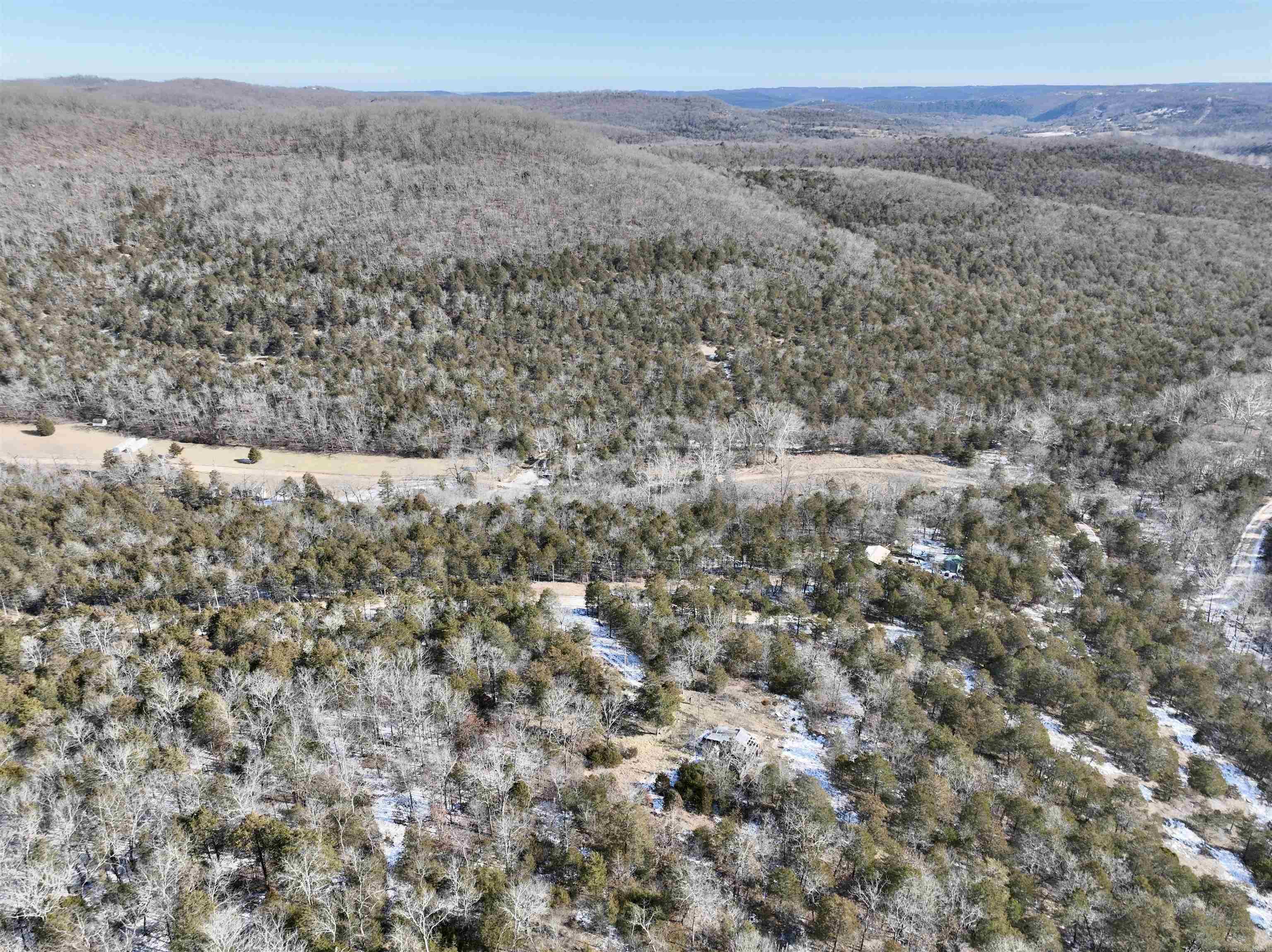 Nestled just minutes away from the pristine shores of Beaver Lake in the heart of Northwest Arkansas, this buildable property offers an unparalleled opportunity for those seeking a rural haven with breathtaking surroundings. With multiple building locations to choose from, each spot on this land presents a unique vantage point to enjoy the panoramic views that stretch as far as the eye can see. The convenience of having electric nearby ensures that modern amenities are within reach, while the property's seclusion and privacy create an idyllic retreat. Majestic rock formations punctuate the landscape, adding a touch of natural beauty to the already stunning scenery. The land features large flat benches, providing ideal spaces for construction and outdoor activities. Loaded with hardwood timber, this property not only offers aesthetic appeal but also holds great investment potential. Plus, there is a recent survey showing the property boundary that will provide a peace of mind for any prospective buyer. Wildlife enthusiasts will appreciate the abundant game sign throughout the area, highlighting the thriving ecosystem that calls this rural escape home.