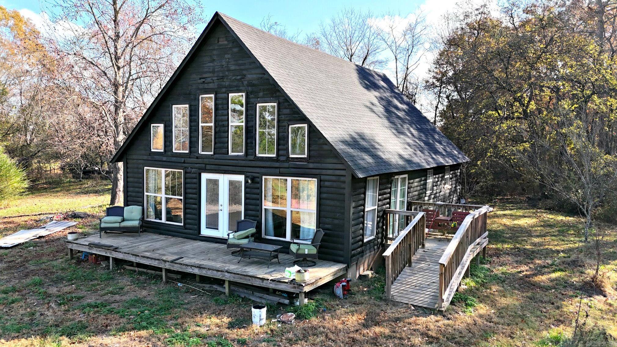 3-bedroom, 2-bath home built in 2009 with approximately 1,616 square feet of living area on about 2.29 acres. The living room features a large wall of windows that provides expansive views of surrounding pastureland and distant mountains, along with high ceilings and natural wood accents for an open feel. The floor plan offers an open main living area with generous natural light throughout. Outside, the acreage includes mature trees, natural foliage, and open areas that contribute to a rural setting with a sense of privacy. The property is located within driving distance of the Ouachita River, ATV trail systems, and other area outdoor recreation, which may appeal to buyers seeking a country residence or periodic retreat. Buyers should verify all square footage, acreage, and proximity to recreation areas, as well as any intended use.