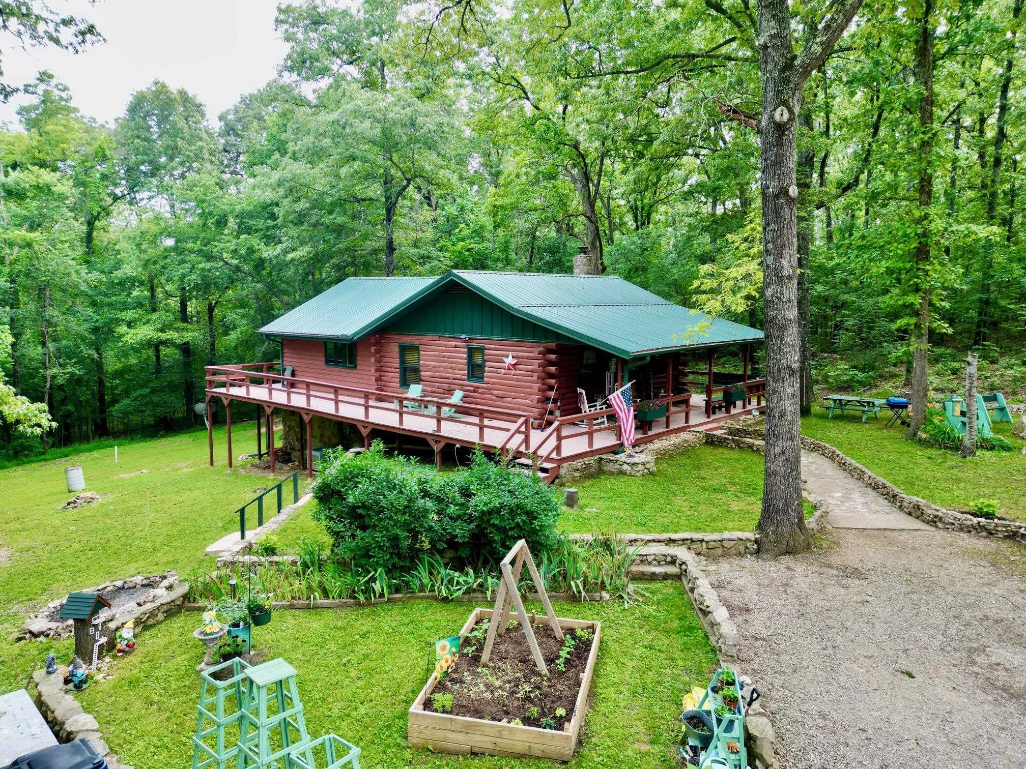 MOTIVATED SELLER!! Nestled in the woods is a beautifully maintained & landscaped 2 level log/cedar home on 4.78 ac m/l. Located just a short drive to downtown Hardy for shopping, dining & entertainment, and close to Spring River for floating, fishing & kayaking. Come in and unpack your bags to start living the country life. The kitchen is a cook's delight-equipped with fridge, dishwasher, range & microwave. Oak cabinets feature pull-out shelves & pantry. Walls & ceilings are mostly log, pine T&G; flooring is wood, hickory & tile. The main level has a large dining room, bath & large bedroom. The lower level—with inside and outside access— can easily be a second living area. The bathroom has an oversized custom walk-in shower. Both bedrooms can handle a king-sized bed with ease & both have large closets. There is a separate laundry with washer & dryer, storage closets & mud room. Other features: Metal roof, loft, 360 degree wrap around deck, Thermopane windows and sliding glass doors. 12x24 storage building. Ample parking for vehicles. Fiber Optic internet (NEXT). City water. Amenity lot in Cherokee Village featuring 2 golf courses & 7 lakes is included with sale of property.
