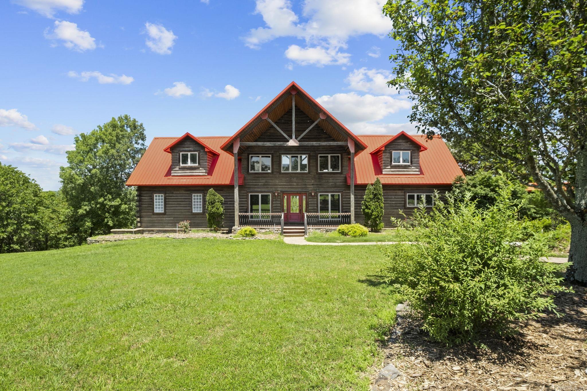 Discover unparalleled beauty and breathtaking views on your own, private 60-acre oasis! This prestigious estate features a custom oak log home with a wrap-around porch, offering panoramic vistas from its wood-lined walls. Primary Suite on the main level. Upstairs, two guest suites connect to a living/bonus area, complemented by two additional bedrooms and a lower level with a walk-out patio. Calling all who wish to homestead/ live away from the world or those looking for a corporate retreat center!  Driveway is 0.9 of a mile long. Highlight of the property is the 60 x 80 barndominium, built in 2010, with a 3BR/ 2BA full living quarters. Unique touches include a cedar-lined ceiling, surround sound, and a custom kitchen with high-profile stainless steel appliances. A workshop area with multi-work stations and indoor RV parking add versatility, while stairs lead to three expansive bedrooms or multipurpose rooms and a full bath. Both dwellings are equipped with zoned heating and air conditioning and their own generators. Perfect for a family retreat or potential wedding venue, this property offers endless possibilities.  Agents see Rmks- Sq ft approx, pls measure.