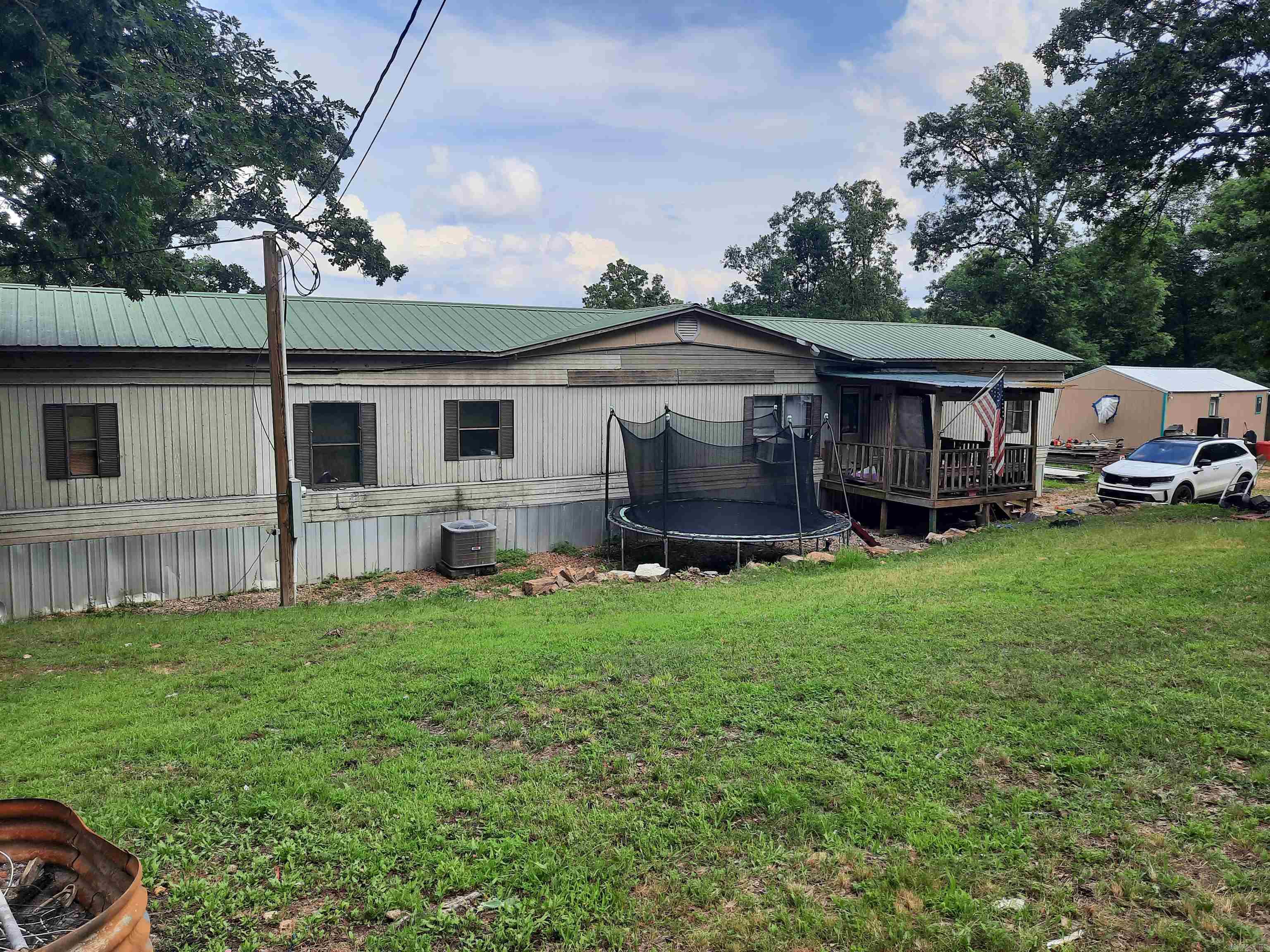 Here is a very affordable home, complete with shop, located in country but convenient to town on 3.20 acres.  Mobile home has metal roof, front porch and covered back deck, home offer 3 bedrooms, plus a nursey off primary bedroom, 1 1/2 bath, needs some TLC but ready for you to make it your own. Take a look.