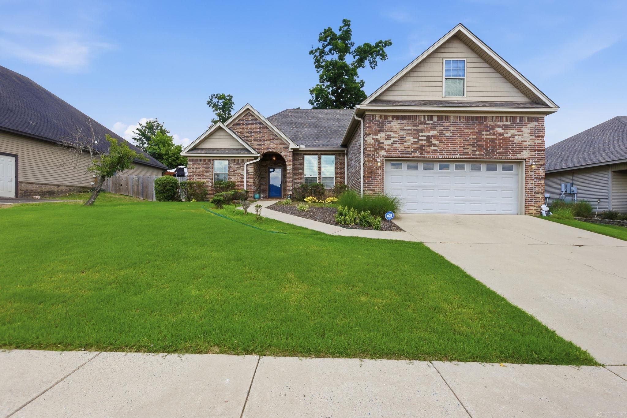 This well-maintained Oak Glenn home offers welcoming gathering spaces, a functional floor plan, and inviting outdoor living. With four bedrooms and three full bathrooms, the layout includes three main-level bedrooms, including the primary suite, plus a private upstairs bedroom and full bath ideal for guests, extended family, a home office, or flex space. At the heart of the home, the great room features soaring 10-foot ceilings, rich wood flooring, crown molding, and a gas fireplace. The adjoining kitchen opens to the living space with granite countertops, stainless steel appliances, a gas range, pantry, breakfast bar, crown-molded cabinetry, and both breakfast and dining areas. The primary suite offers dual vanities, a soaking tub, walk-in shower, and generous closet space. Outside, the covered patio extends your living space and overlooks a fully fenced backyard with a mature shade tree and terraced landscaping, perfect for relaxing or entertaining. An attached two-car garage, zoned HVAC, fresh interior paint, and a roof replaced in 2024 add comfort & peace of mind. Located in one of Bryant’s established neighborhoods, this move-in ready home is ready to be enjoyed from day one.