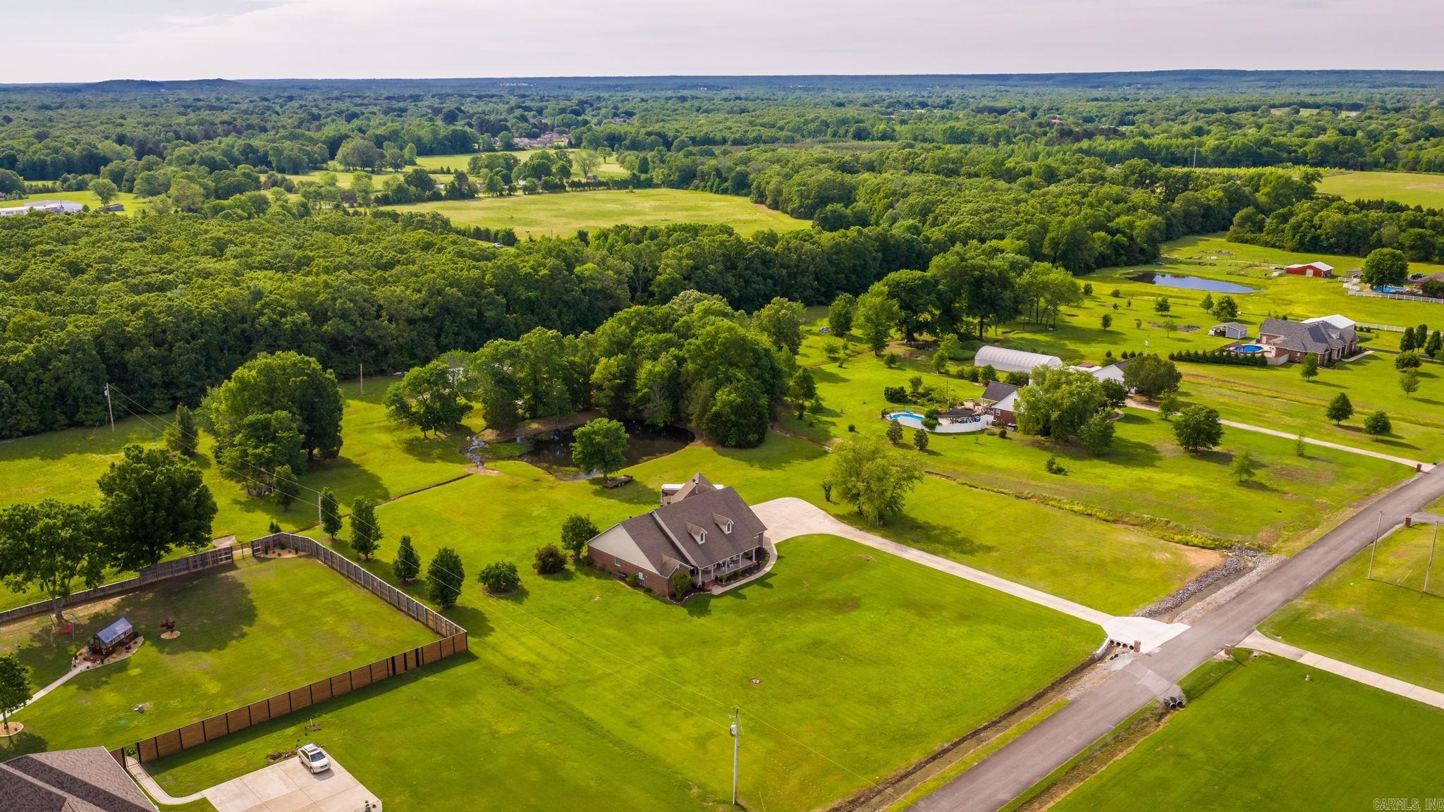WANT IT ALL IN CONWAY?  Large Home with 3-Car Garage and Safe Room, almost 5 Acres, Stocked Fishing Pond and a 30x40 Shop, just outside of Conway City Limits. This home has it all. This home features 4 bedrooms and 3 bathrooms, plus an office and 2 living areas downstairs and a large game room/5th Bedroom upstairs. Built for efficiency and strength with 2x6 exterior walls and insulation in the exterior and interior walls. The expansive back porch is covered with a vented grill area and TV that overlooked the massive back yard and pond that is stocked with fish.  The roof and both A/C Units have been replaced in the last 5 years and there's nearly enough concrete on the driveway to land a plane. There is storage space for all your toys, room for the family and a porch and yard for all your friends.  Don't miss this one!