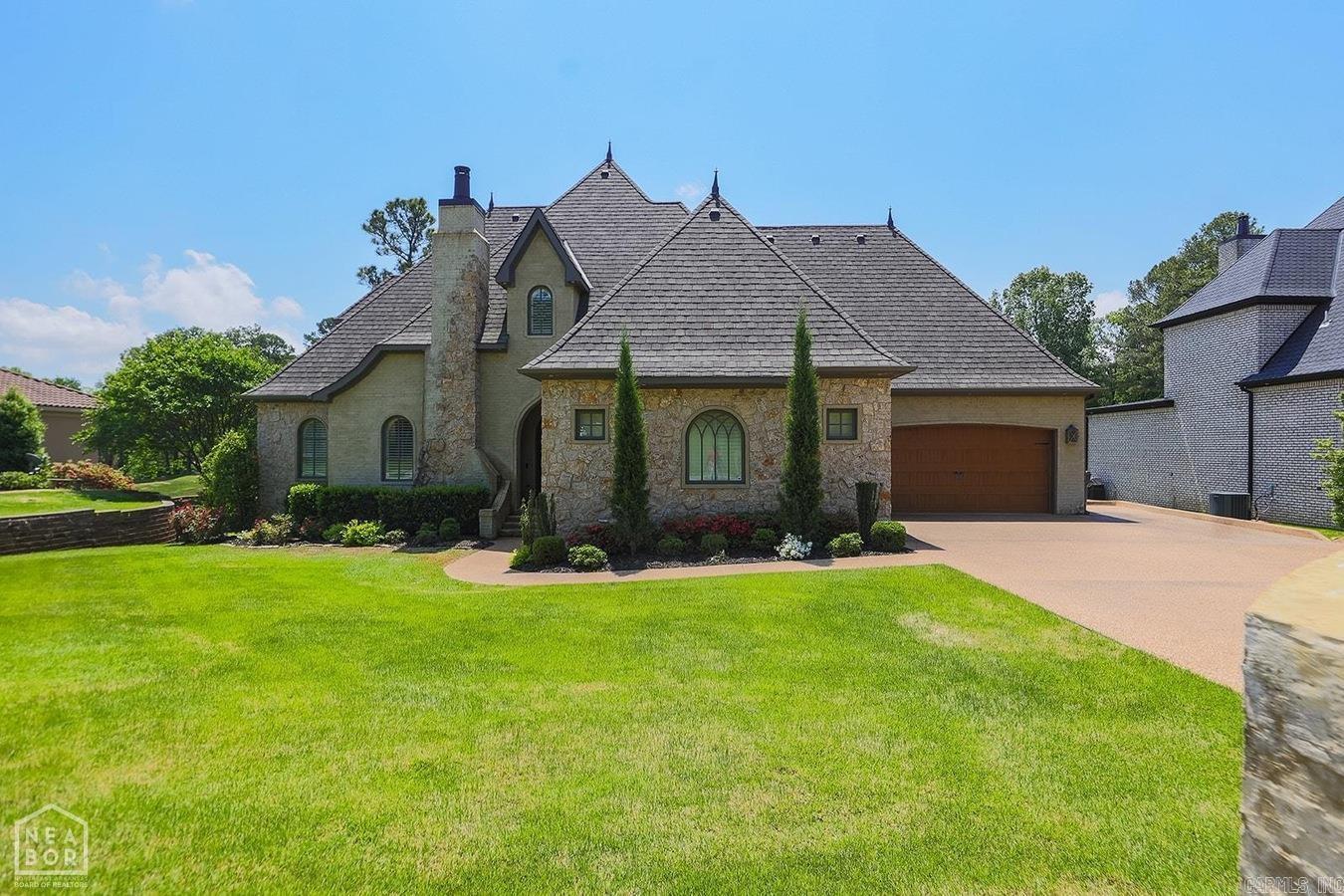 Ridgepointe home on the course built by Tommy Westbrook. Experience timeless craftsmanship and modern luxury in this stunning custom home showcasing exceptional curb appeal and lush landscaping. The exterior's slurry brick and stone design sets the tone for the architectural detail found throughout. Inside, the main floor offers 3 bedrooms and 2.5 baths, anchored by a soaring 17-foot brick fireplace and vaulted wood ceiling in the living room. The study just off the entry exudes character with shiplap walls, diamond grid ceiling detail, and its own fireplace. The heart of the home is a showstopping kitchen designed by Westbrook Premier Kitchen & Bath, featuring professional-grade appliances, a 48'' dual-fuel range, ice maker, apron sink, zinc mantle-style hood, and a massive island topped with reclaimed white oak. The primary suite is a retreat of its own with custom ceiling beams, transom-style windows, private patio access, and a spa-inspired bath boasting a large dual-head shower, his and her vanities, and a custom closet with direct laundry access.