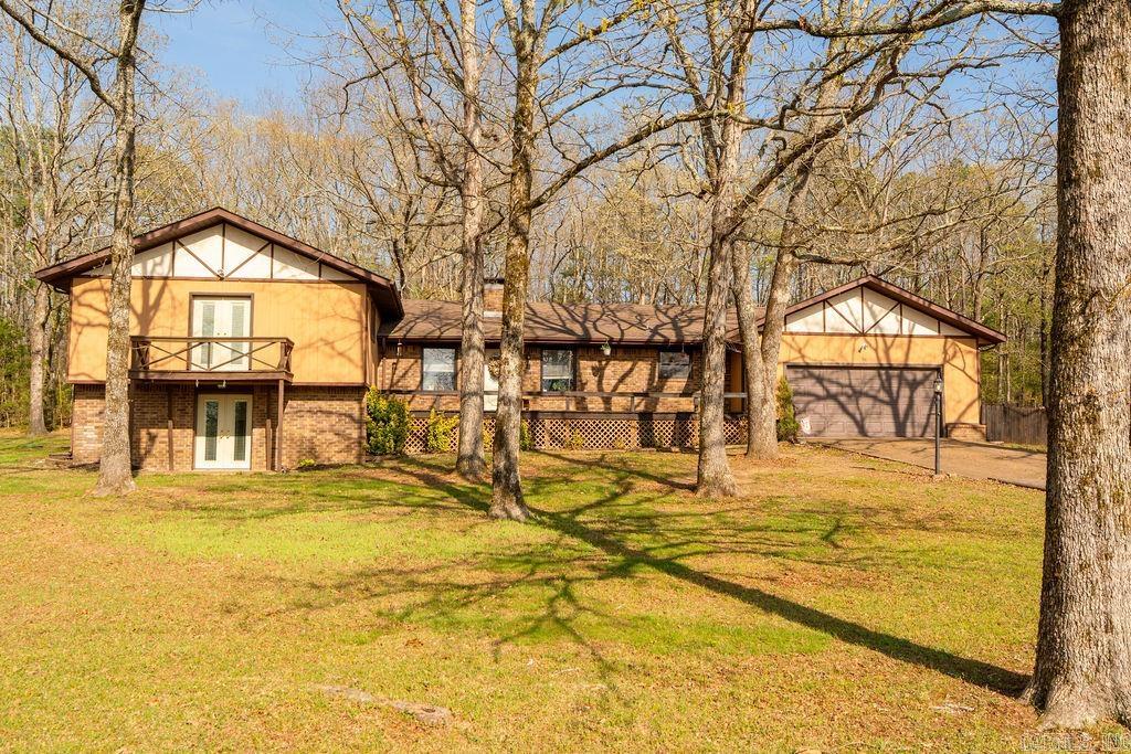 Enjoy privacy and space with this split-level home on just under 3 wooded acres in a quiet neighborhood near Greers Ferry Lake. Featuring 3 bedrooms, 2.5 baths, and a versatile bonus basement with ground-level walkout, this home offers flexible living options. Inside, you’ll find an inviting layout with a gas log fireplace, large living area and laundry room, and open-concept kitchen with breakfast bar and dining area. Ample storage is found throughout. New Interior and Exterior doors throughout. Outside, the property includes a screened in back porch, garden area, partial chain-link fencing for pets, and plenty of room for outdoor activities. A  large heated shop building adds valuable workspace or storage. Additional highlights include ample parking for boats or RVs. Conveniently located just 1.9 miles from the Old Hwy 25 boat ramp, this property is ideal for full-time living or a lake getaway.  Roof has 25 year warranty which transfers to new owner.