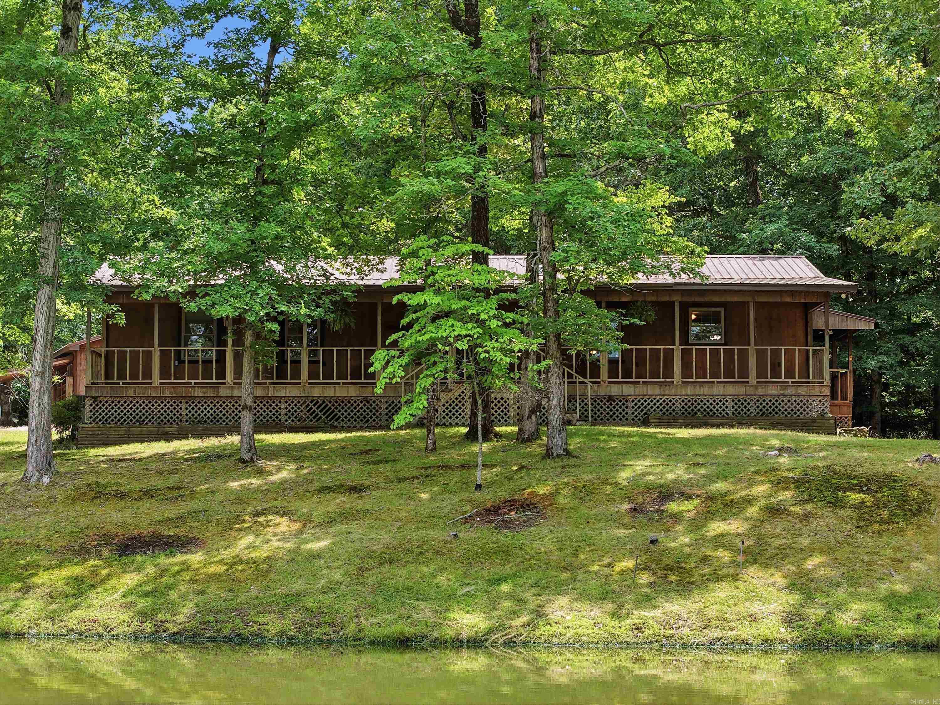 Experience country living at its finest with this charming 3-bedroom, 2-bathroom home, offering approximately 1,800 sq ft on 3.61 beautiful acres. Enjoy the convenience of Saline River access with a boat ramp located less than 2 minutes away, perfect for fishing, kayaking, or spending the day on the water. This property is perfect for those who love the outdoors and need space to spread out. Inside, you’ll find a spacious living area with a cozy wood-burning stove, a large pantry, and a primary bedroom with an en-suite bathroom. The sunroom provides the perfect spot to relax and enjoy peaceful views of the property year-round. Step outside to enjoy the long, spacious front porch, ideal for morning coffee or evening sunsets. The property also features a pond, garden space, fish cleaning station, and plenty of room for outdoor hobbies. Additional highlights include a workshop with lean-to, outdoor storage, and a durable metal roof. Enjoy peaceful country living; this property offers it all. Additional 40x80 Shop & 1.56 Land for Sale, address 4311 Peeler Bend MLS #26019697