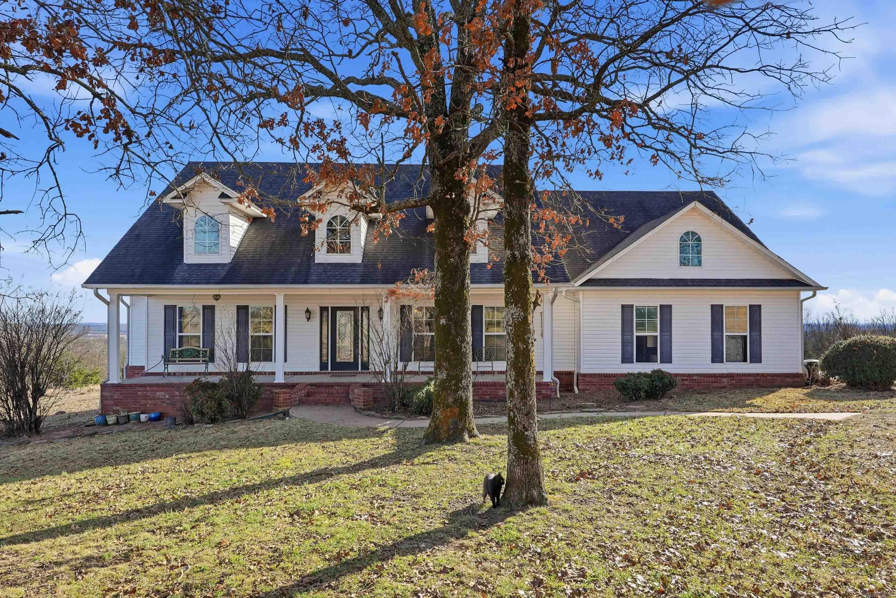Stunning custom built country retreat with breathtaking views! This beautifully maintained home sits on picturesque acreage, offering rolling pastureland, mature trees, and expansive views in every direction. A charming front porch welcomes you inside, while the spacious deck provides the perfect setting to relax, entertain, or enjoy peaceful sunsets overlooking the countryside. Inside, the open and inviting living area features tall ceilings, abundant natural light, and a cozy fireplace with custom built-ins. The thoughtfully designed layout offers comfortable living with well-appointed spaces ideal for both everyday life and gatherings. Large windows frame the scenic views, bringing the outdoors in. Outside, the land is partially fenced and offers open pasture space ideal for a horse or two, along with a barn for livestock, storage, or hobby use. With room to roam and enjoy the privacy of country living, this custom built home offers space, views, and versatility while remaining conveniently located.