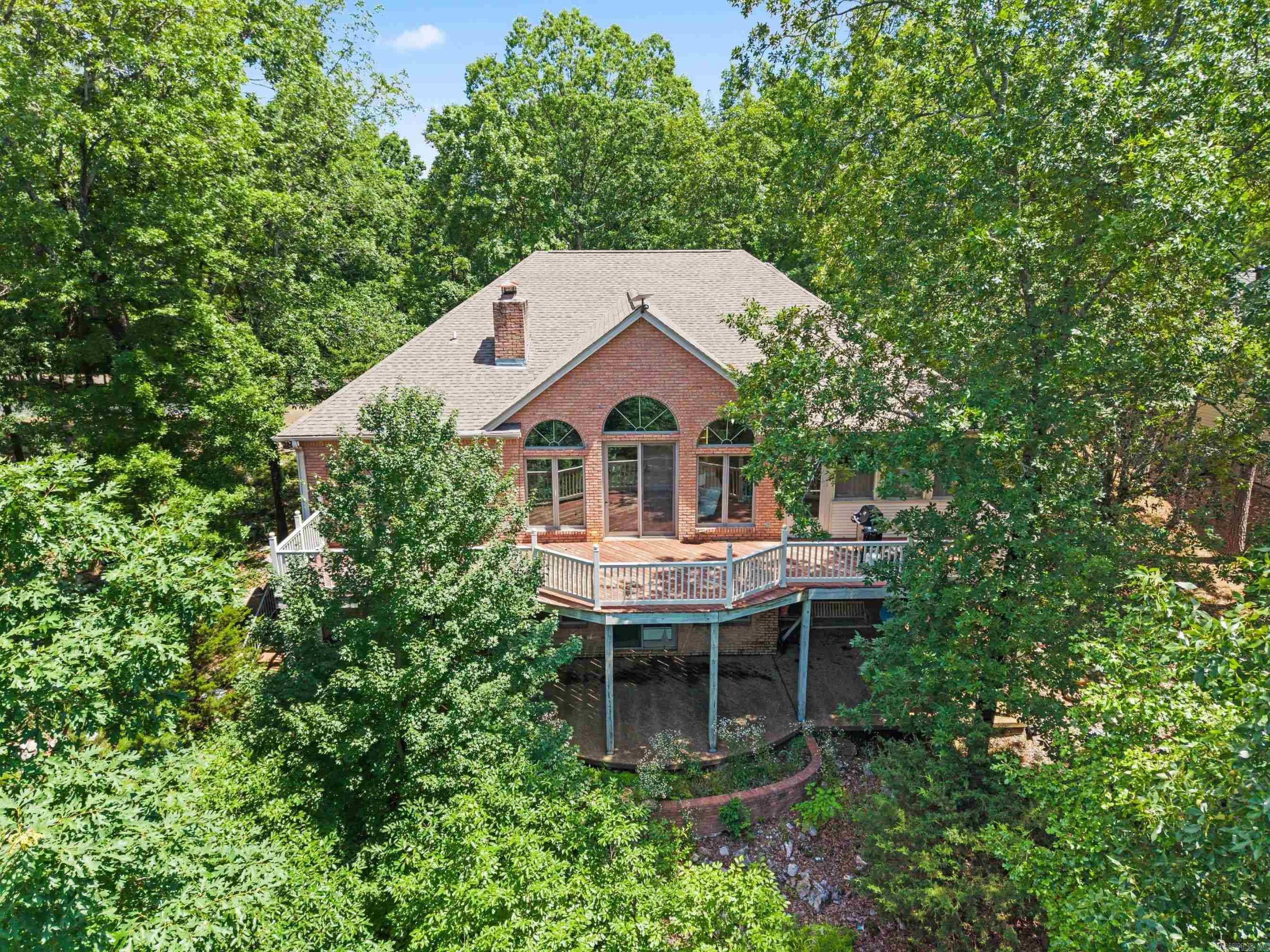 Perched at over 1,000 feet in elevation, this beautiful home captures breathtaking long-range vista views year-round, with seasonal lake views in the winter. Expansive windows fill the home with natural light and showcase the stunning scenery from multiple rooms. The main level offers convenient one-level living with a spacious primary suite featuring a luxury bath and walk-in closet, plus two guest bedrooms and a full bath. The open floor plan includes a large kitchen with abundant cabinetry, generous counter space, breakfast area, and a living room with a see-through fireplace shared with an adjoining room. The fully finished lower level provides exceptional flexibility with a second living area or game room, second fireplace, a fourth bedroom, full bath, two multi-use rooms ideal for hobbies, fitness, or office space, and a storm shelter. A rare combination of incredible views, versatile living space, and comfortable everyday living in Hot Springs Village.