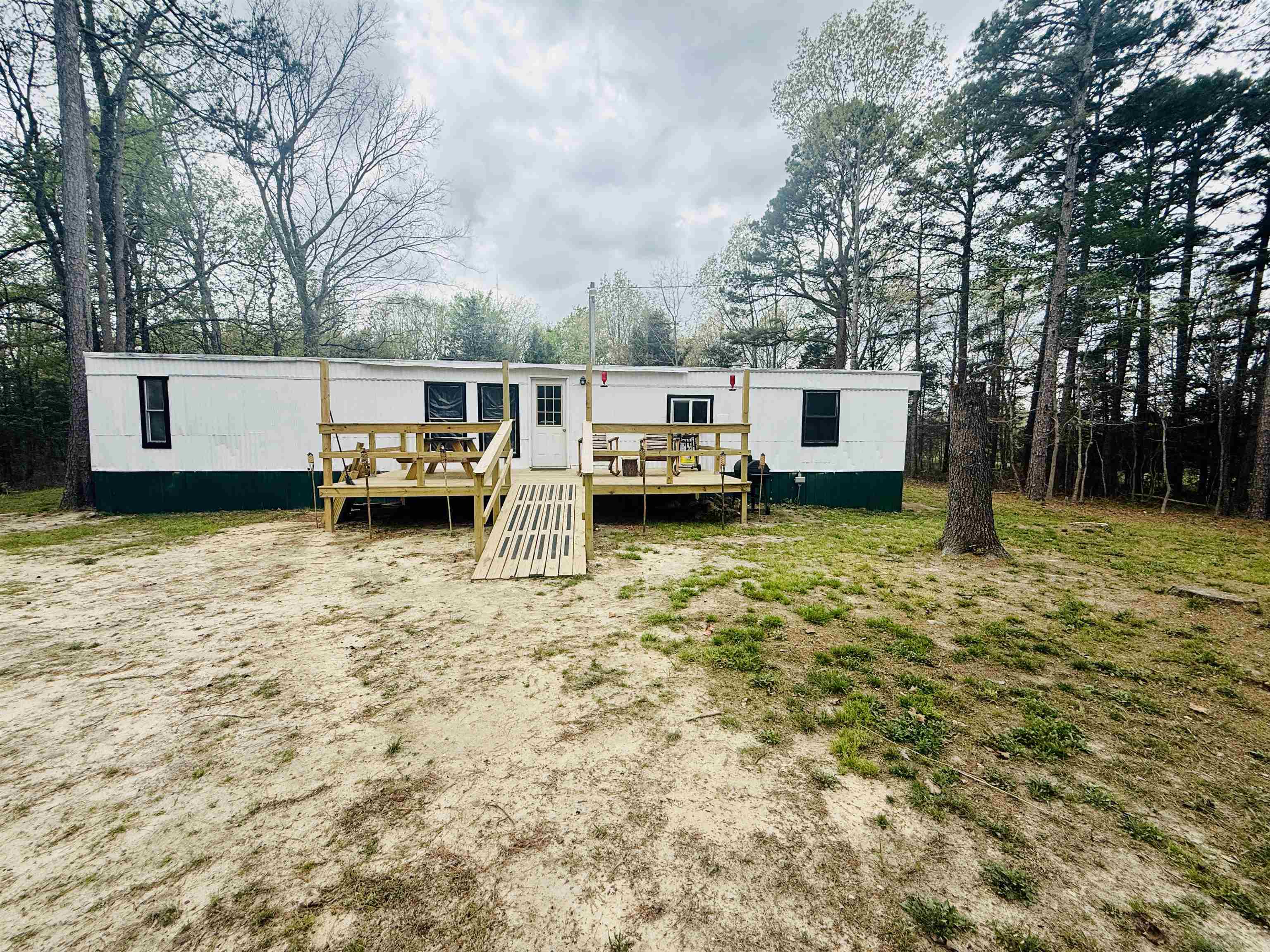 Just outside the city limits of Evening Shade! This mobile home sets on a secluded acre. Most everything has been remodeled or updated. It has city water and it's all electric. It is plumbed for propane but it's capped off. Rustic barn wood adds to the charm. New flooring throughout. All new electrical (wiring, outlets, switches & breaker box). All new plumbing from the meter and throughout the home. All new bathroom & kitchen fixtures and appliances. New stack washer/dryer. New 40 gal elec water heater. New Mini-Split heat & air. New wood-burning fireplace with a fire wall. Roof has been coated & sealed. New deck. Lumber will be left that was purchased to finish canopy over deck. Electric wall heaters installed 2019. Septic tank 9 yrs old.  Also included is a 12x24 storage building with electric. Newly planted fruit trees. There's plenty room to put in a garden or have chickens or other livestock. NAEC electric & Next internet provider. Avg utilities (water/elc) $215/month. This is a great opportunity for a cash buyer to set up a homestead. This type property is in high demand so act fast and call us today! Wildlife is spotted on the property quite often. Move-in Ready!