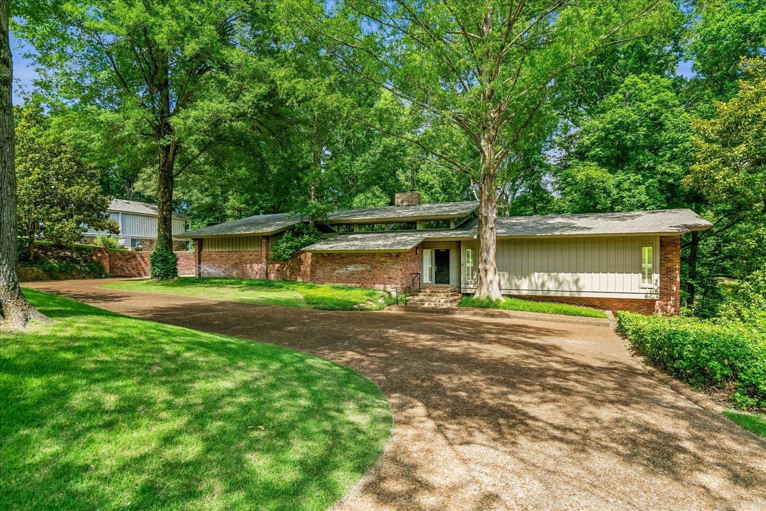 Welcome to the Lockhart Home, a mid-century modernist masterpiece designed by acclaimed Memphis architect Buddy Hord and masterfully built in 1969 by Devereux & Finch Construction. True to the era’s finest architectural traditions, Hord seamlessly blends upscale sophistication with functional luxury. The design utilizes soaring vaulted ceilings and intentional transitions in flooring to naturally define living spaces while guiding the home's intuitive flow. Floor-to-ceiling glass walls and dramatic clerestory windows flood the interior with soft, diffused natural light and erase the boundary between indoors and nature. High-utility custom cabinetry offers abundant, seamless storage throughout. The exceptional design extends outdoors with grounds crafted by Wiley Jones, a graduate of the Harvard Graduate School of Design and one of the Midsouth’s most renowned landscape architects. His vision allows the outdoor living spaces to blend seamlessly into the surrounding topography. Meticulously maintained by its original owners, this architectural gem is being offered to the market for the very first time in 57 years.