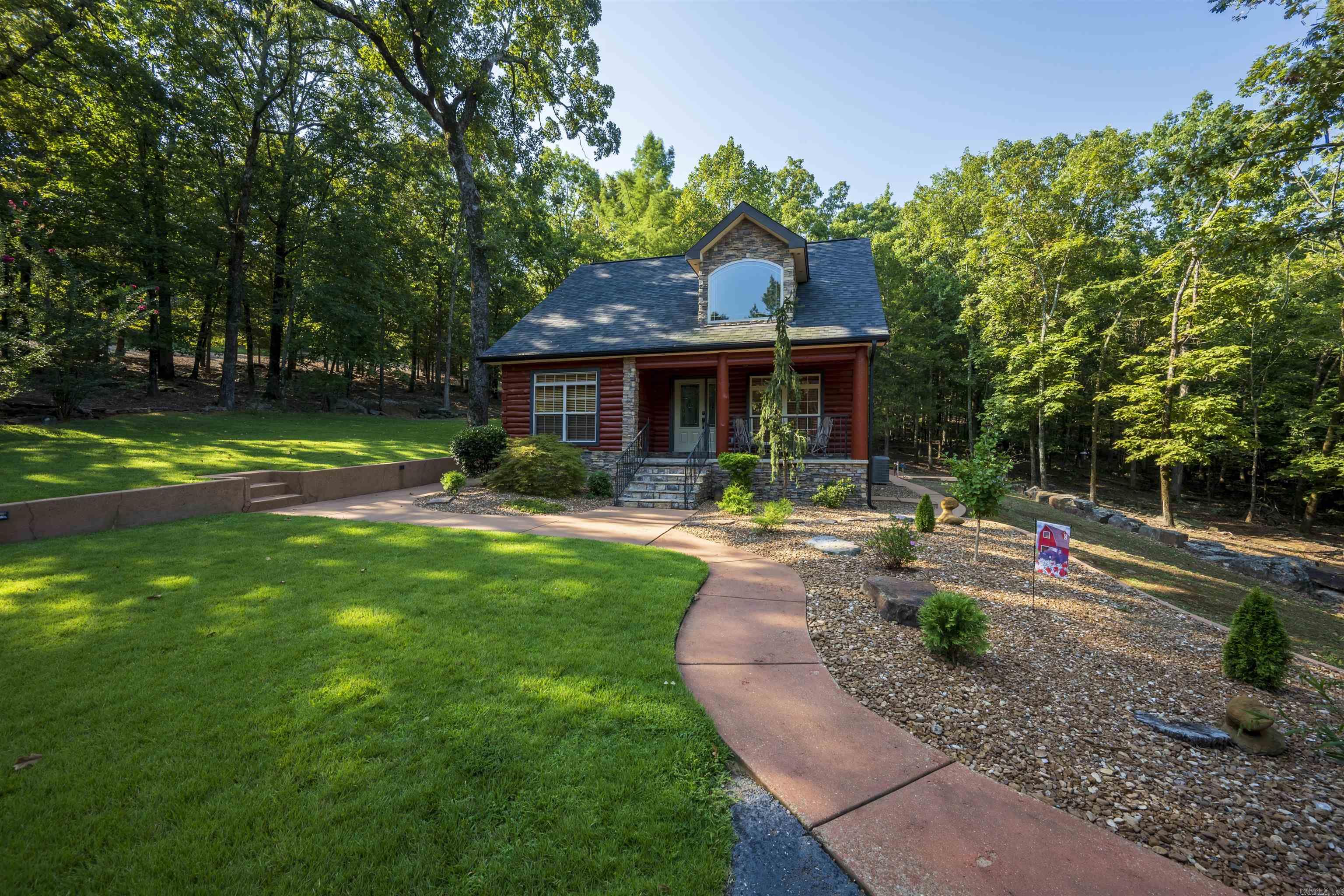 TWO PROPERTIES. TWO SEPARATE ENTRANCES. ACREAGE. 30x40 SHOP.  A DREAMY, ONE-OF-A-KIND PROPERTY THAT RARELY BECOMES AVAILABLE.  Set on 12.86 m/l acres, offering privacy, flexibility, and a layout designed for multiple living and income opportunities. The stunning log home (est. 1,827 sq ft, built 2006) features 2 bedrooms, 2 bathrooms, a spacious den/flex room, soaring ceilings, tall windows, and a beautifully designed kitchen with stainless steel appliances. Recent updates include newer shingles (2024), energy-efficient HVAC systems, freshly re-stained logs (2025), exterior drainage improvements, 400-amp underground electrical service, and beautiful curb appeal.  The second residence (est. 861 sq ft) offers 2 bedrooms, 1 bathroom, mini-split systems, all appliances conveying, and its own private driveway. Ideal for a mother-in-law suite, guest house, multi-generational living, long-term rental, or short-term rental such as Airbnb or VRBO.  Additional features include a heated and cooled 30x40 shop with half bath, soundproofing, and floor drains, a 2-car garage with storage, plus gravel parking/equipment area. A rare blend of space, functionality, and opportunity.