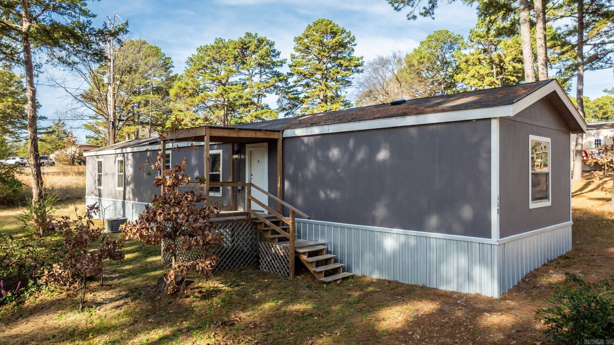 PARTIALLY FURNISHED + GREAT CONDITION! You'll love being by the lake! Watch the  video walkthrough on YouTube!  This move-in ready 3 bed, 2 bath single-wide mobile home on a permanent foundation, nestled on two lots (a rare find in this subdivision!) offers extra space for outdoor living and future plans. You'll love the covered front porch to sit and enjoy the scenery as well as the room to move around on these 2 lots! New LVP flooring, WH 2023, newer appliances, and roof was resealed in 2020. The primary bedroom has a fabulous walk-in closet and a shower and separate tub. Fairfield Bay is a resort-style lake community on beautiful Greers Ferry Lake. Enjoy boating, fishing, or paddleboarding from the Fairfield Bay Marina, tee off on championship golf courses, or enjoy scenic trails like The Bay Trails. There’s also tennis/pickleball courts, pools, bowling, golf, local eateries, shopping, and community events that keep life active and social.  Perfect for year-round living or a peaceful getaway, this property captures the best of Arkansas outdoor lifestyle and small-town charm. Make sure to check this one out!