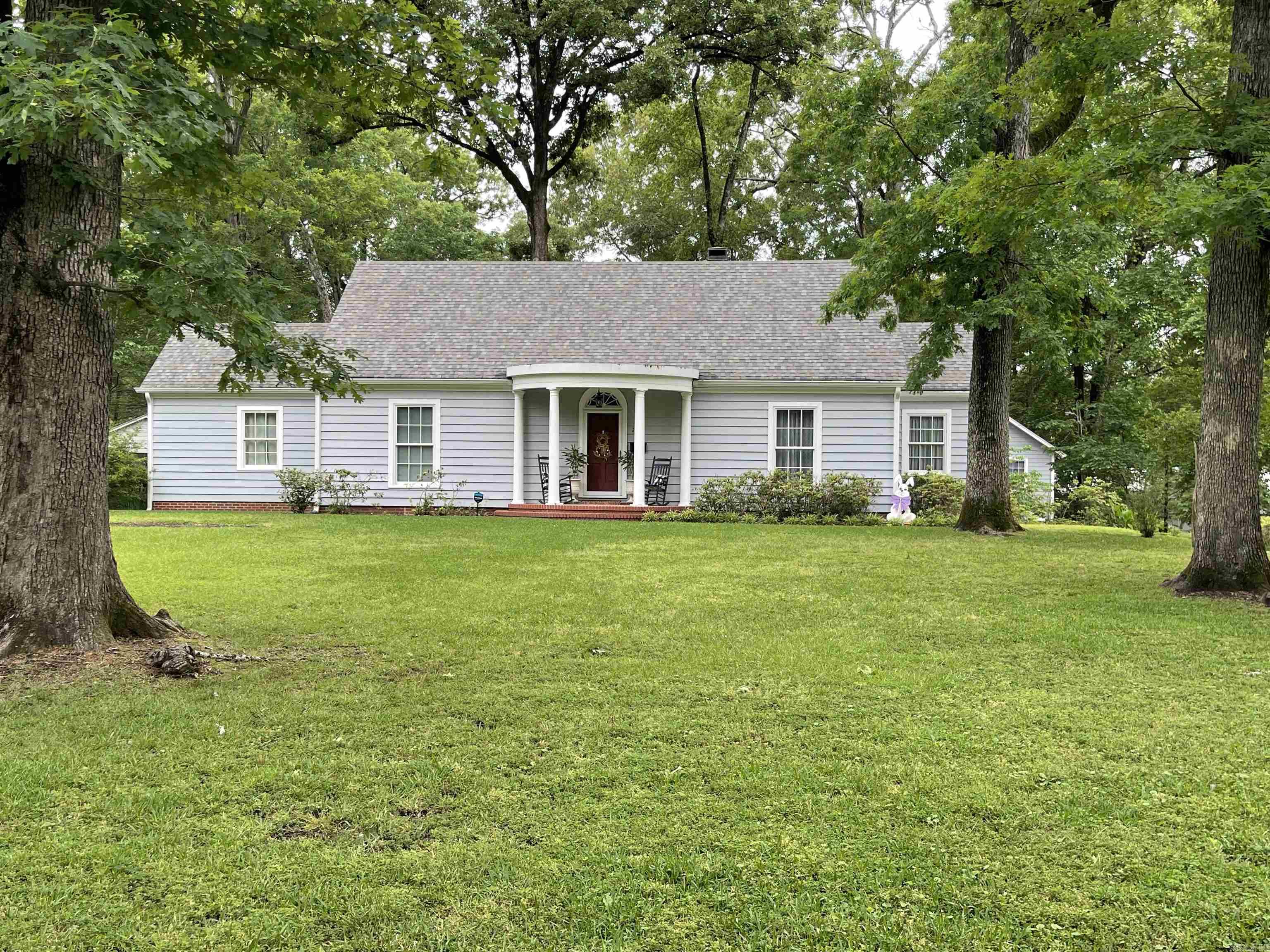 Built in 1947, this stately home blends timeless character with a warm, inviting presence, set gracefully on a beautiful, expansive lot surrounded by mature trees that offer both shade and serenity.  Inside, large windows fill the space with natural light and frame picturesque views in every direction, creating a seamless connection to the outdoors.  The thoughtfully designed layout features four bedrooms and three baths, with two bedrooms conveniently located on the main level and two additional bedrooms upstairs, offering flexibility for family living or guests. This property captures the essence of classic elegance with room to grow and enjoy.  Also includes a 600 sq ft. apartment above the double garage with kitchenette, living room, bedroom and bath UPDATES- APARTMENT- 2024 New electrical  2024 New 30 gallon Hot Water Heater  2024 Plumbing installed for shower  2024-2025 Apartment used as income property- $500 plus utilities HOUSE- 2024 New 50 galllon Hot Water Heater installed 2026 New 5-ton HVAC installed  2024 Kitchen updated with additional cabinetry, marble countertops 2024 New refrigerator and dishwasher 2026 Fresh Exterior Paint