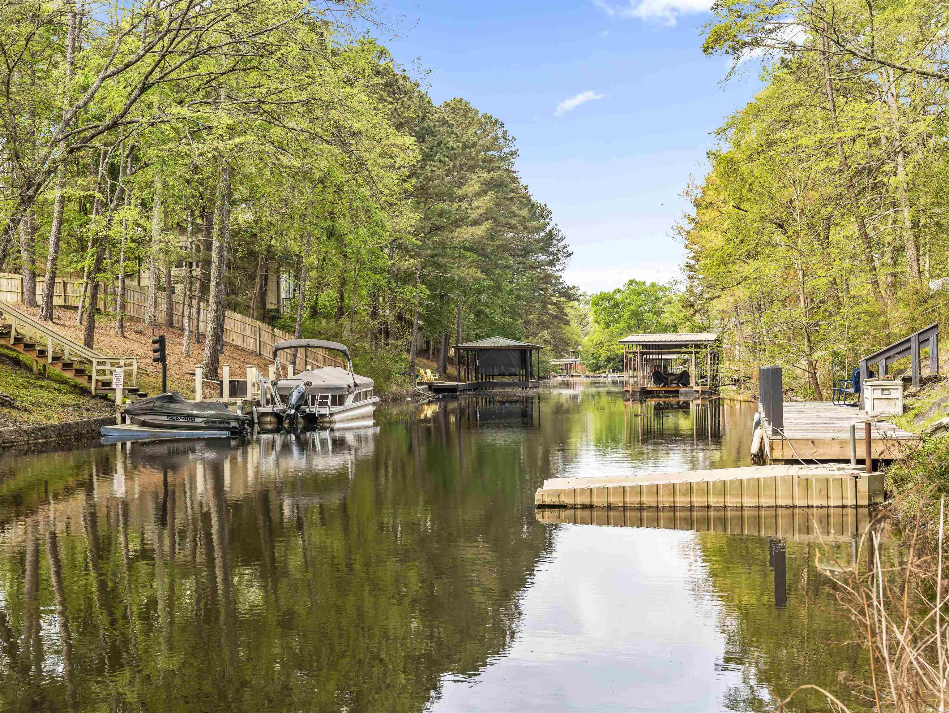 Lake Hamilton Waterfront | Private Dock | 4-Car Garage | Guest Apartment  Rare opportunity to own a beautifully updated Lake Hamilton waterfront property that offers something increasingly difficult to find: a private lakefront home with a  4-car garage, guest apartment, workshop space, and private boat dock—all in a peaceful cove setting. The main residence features comfortable living space with 3 bedrooms and 2 bathrooms, blending timeless character with modern updates. Thoughtfully updated interiors make one owner home move-in ready. Outside is where this property truly stands apart. The attached & detached garages provides space for up to 4 vehicles, boats, lake toys, or a workshop, while the studio apartment above offers ideal accommodations for guests, extended family, a home office, or potential rental income. Mature landscaping & hardscaping creates a private retreat just steps from the water. Enjoy the massive 2 level decks complete with stone firepit...perfect for entertaining after a day on the lake. Comes with a Buyer's Home Warranty New Roof in 2023 (due to hail) Seller is a licensed real estate agent. Call 501-282-2216 for showing appt.