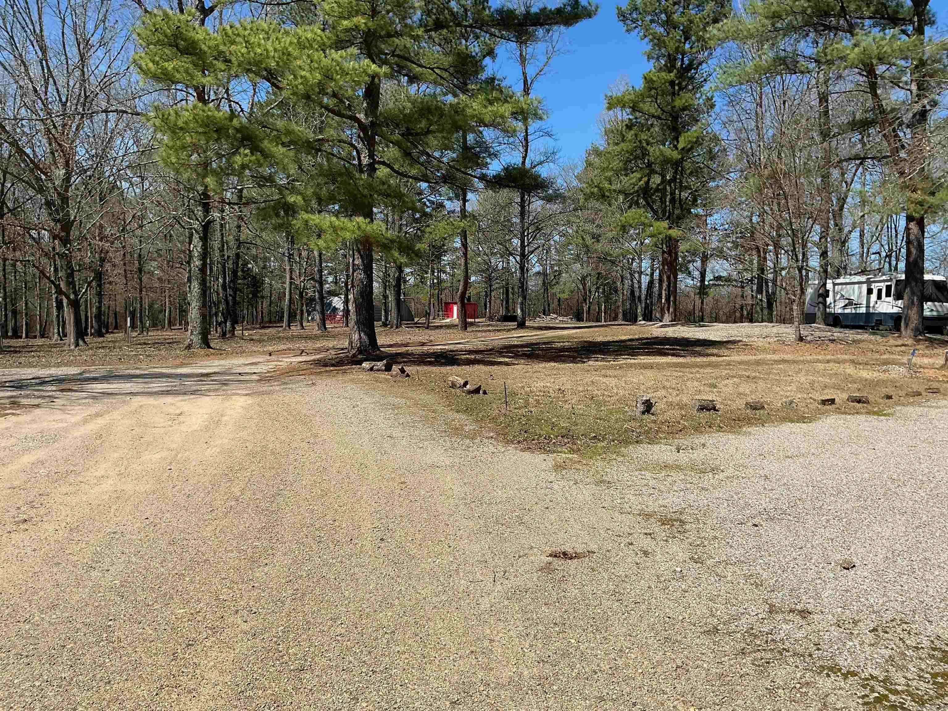 This beautiful 10± acre property located in West Bonnerdale, AR, offers excellent visibility from HWY 70 and presents a wealth of possibilities for development. The site includes 8 pull-through RV spaces with plenty of room to expand, making it a great investment opportunity. With no restrictions, this property is ideal for mobile homes, tiny homes, or even a perfect location for your new dream home. The large 40x60 outbuilding provides ample storage or workspace, and the property is already equipped with 3 septic tanks. Included with the property is a 2004 40ft motorhome. Situated just 5 miles from Lake Hamilton High School, this versatile and scenic land allows you to let your imagination run wild and create something special.