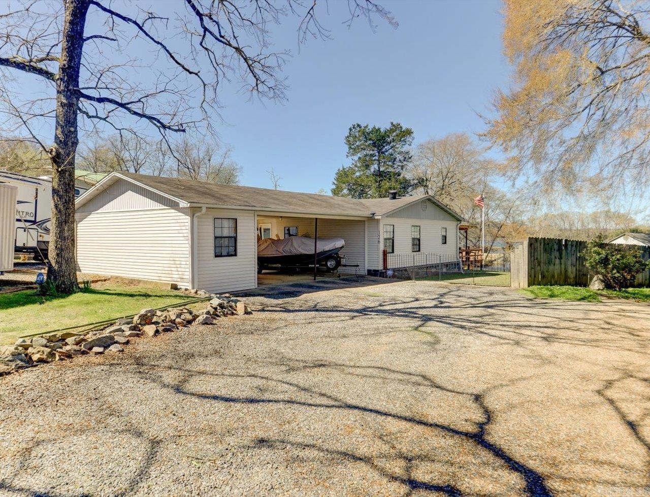 Lakefront Living Meets Total Utility:  Interior: Knotty Pine finished 3BR/2BA + updated kitchen with oversized island.  The "Bonus": Huge multi-purpose room with wall of windows facing the lake and a private half bath. And, back yard has custom fire ring for nights outside by the lake.  For the Toys: Covered dock, double carport, and RV parking (electric).  The Shop: Climate-controlled storage/equipment building with power.  Community: Private subdivision boat launch for easy water access.