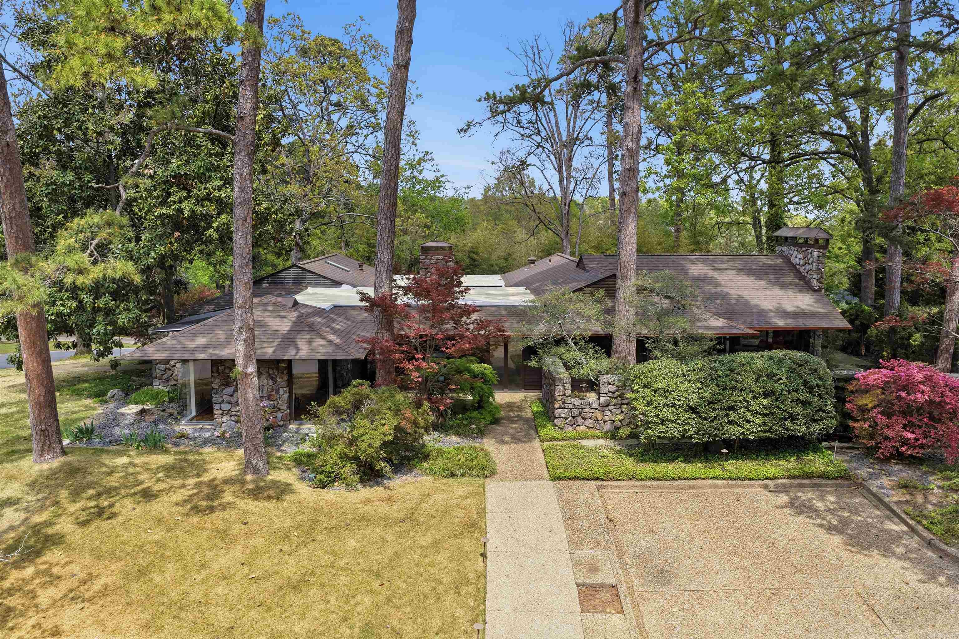 This authentic and iconic mid-century modern residence is ideally positioned on .57 of an acre & offers timeless design, exceptional privacy & a floor plan suited for both everyday living & entertaining on one level. Built in 1963, this architectural gem features an open layout with a separate dining room, formal living room with wood-burning fireplace & a spacious den centered around a private courtyard & patio with incredible natural light. The vaulted family room is surrounded by glass windows which opens to the patio. The kitchen features granite countertops, Viking gas cooktop, double ovens, wine fridge & a large island w/ abundant storage. The private primary suite offers a renovated bathroom with double vanities, soak tub, walk-in shower & built-ins. An office, 2 additional bedrooms with 2 fully renovated bathrooms are also available. Downstairs offers a detached 4th bedroom suite of approximately 295 SF plus a 216 SF safe room. Outdoor amenities include a striking two-sided stone water feature & koi pond & multiple patio spaces for entertaining. Add. highlights include a new roof, 2 new HVAC's & whole home generator, 2-car carport w/ extra parking & electric car charger.
