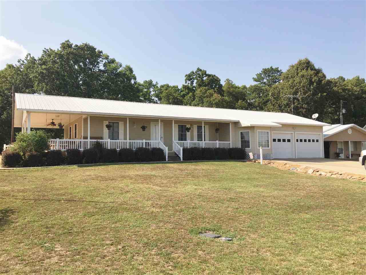 Nice lakefront house with private dock. Large living room with hardwood floors & bay window sitting area. Kitchen has lots of cabinets, tile floors, breakfast nook & granite counter tops. This home has a 2 car garage, guest house and a 2 bay shop that opens on both ends. Also included is a propane powered generator in case the power goes out. Nice in ground storm shelter to keep you safe. Launch ramp across the road. This place is worth a look. Call us today for a showing.
