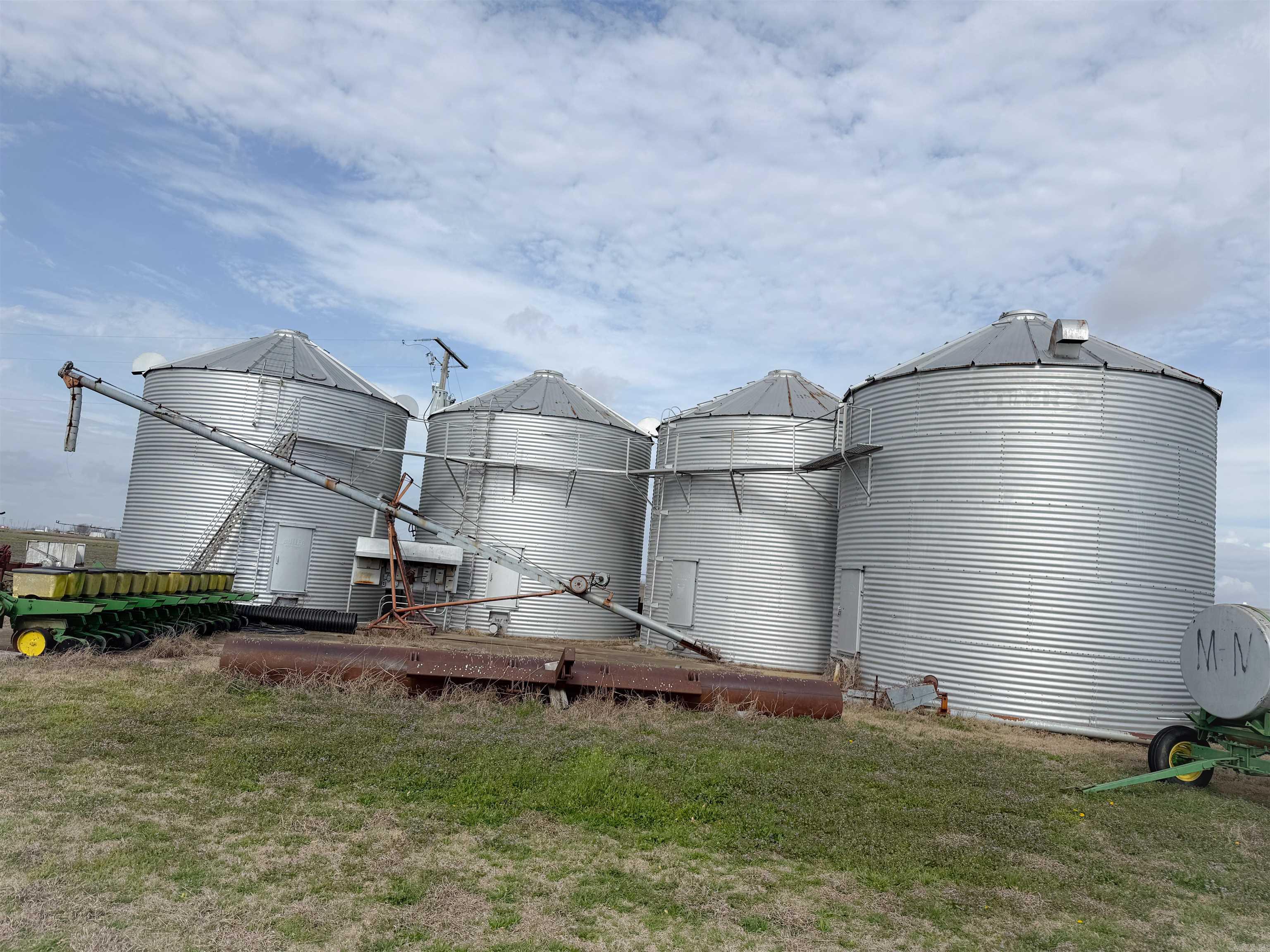 Agricultural property featuring four 12,000 bushel grain bins, offering approximately 48,000 bushels of total grain storage capacity, two of the grain bins have drying capabilities. There is also a 90x60 ft shop ideal for equipment storage.