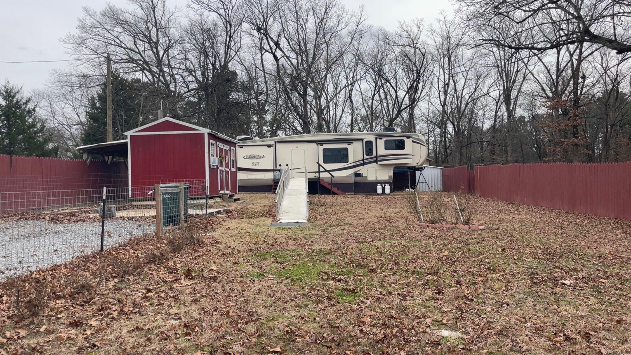 This .06 acres lot comes with a 2018 Cedar Creek 42 5th wheel camper that has been skirted, a 10x16' building that has been converted into a laundry room with washer and dyer hookups, 2 car metal carport utilized as an outdoor area with a mounted television and burn barrel, and is fenced in. Property has been used as a residence and as a rental property. Call today to schedule your personal showing.