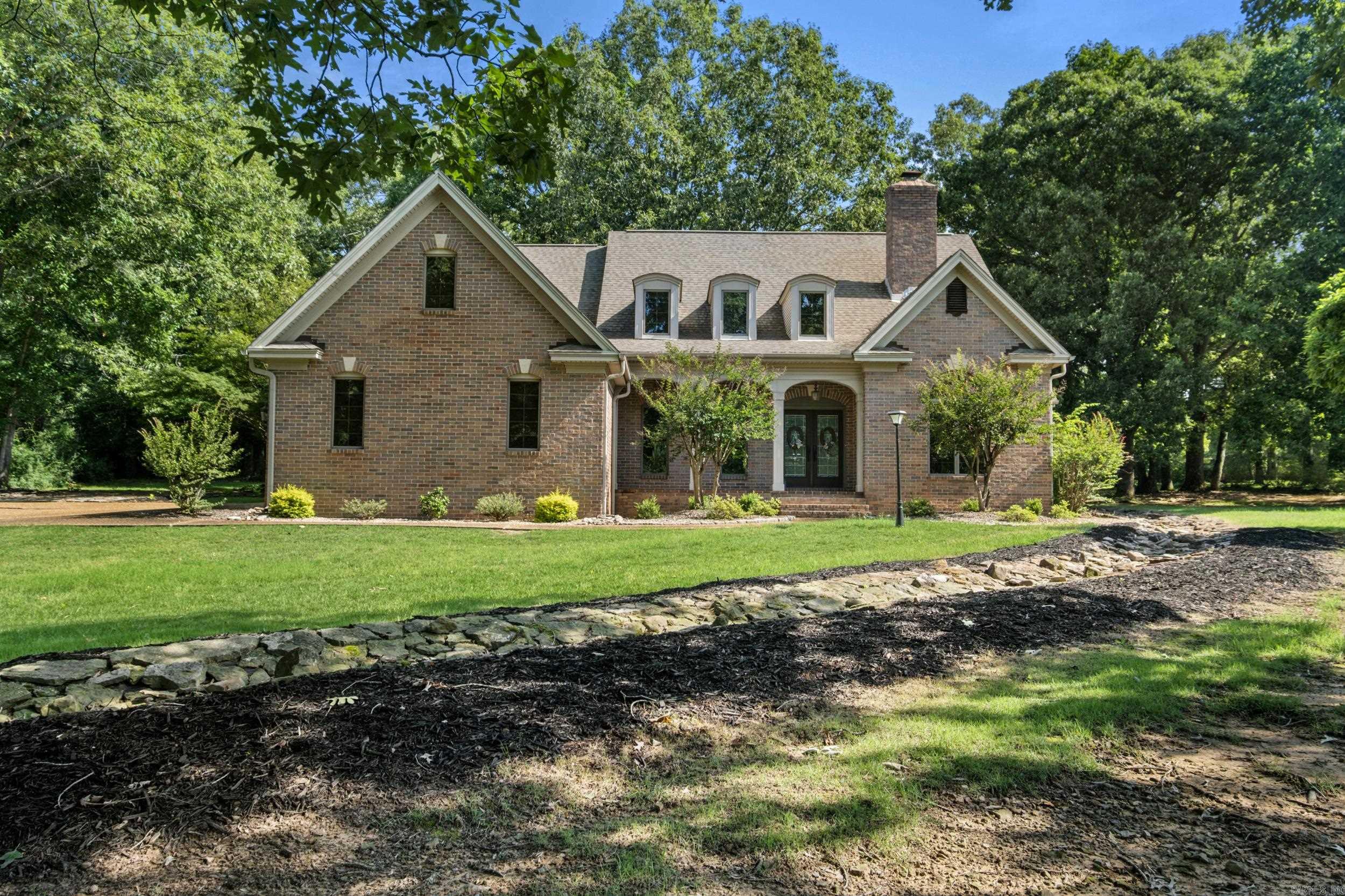 NO it's not the Biltmore Estate BUT you might compare this custom built home to that estate!  The arches on the front lead to some double doors opening to a grand staircase at the front entrance with gorgeous wood floors and fir wood trim throughout this home.  Lots of Andersen windows allow light and the Pella outside doors inhance the R-50 and R-19 insulation for a air tight seal.  Formal dining rm, office/study, living rm, gourmet kitchen with pull out pantry (lots of cabinets) and the primary bdrm is downstairs.  3 bdrms and 2 bths upstairs with a cat walk overlooking the living area 2 wood burning fireplaces with an additional woodstove in the hearth rm.  2 water heaters New HVAC 2025 instant hot water for kitchen sink. Just to name a few amenities on the inside!  This home offers character from either entrance.  A back patio with outside grill, lots of trees for shade and landscaping galore!  The wood burning fireplaces have new steel lined chinmney lining.  3 car garage is a plus!  AND the landscaping!!! This is not a cookie cutter home and it's looking for it's next family to love!